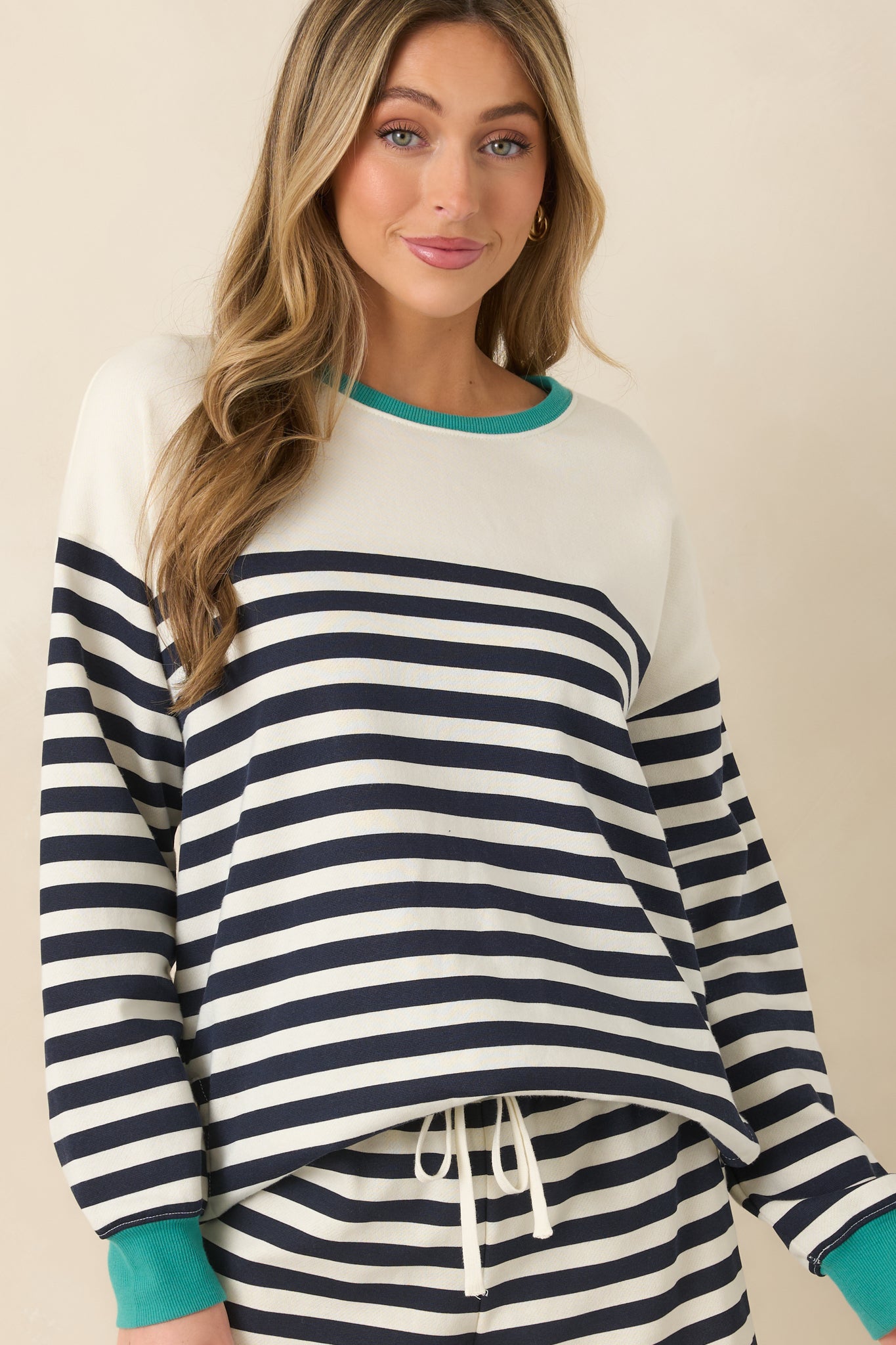 Cropped view of navy and ivory striped sweatshirt highlighting the teal ribbed neckline and soft knit texture.