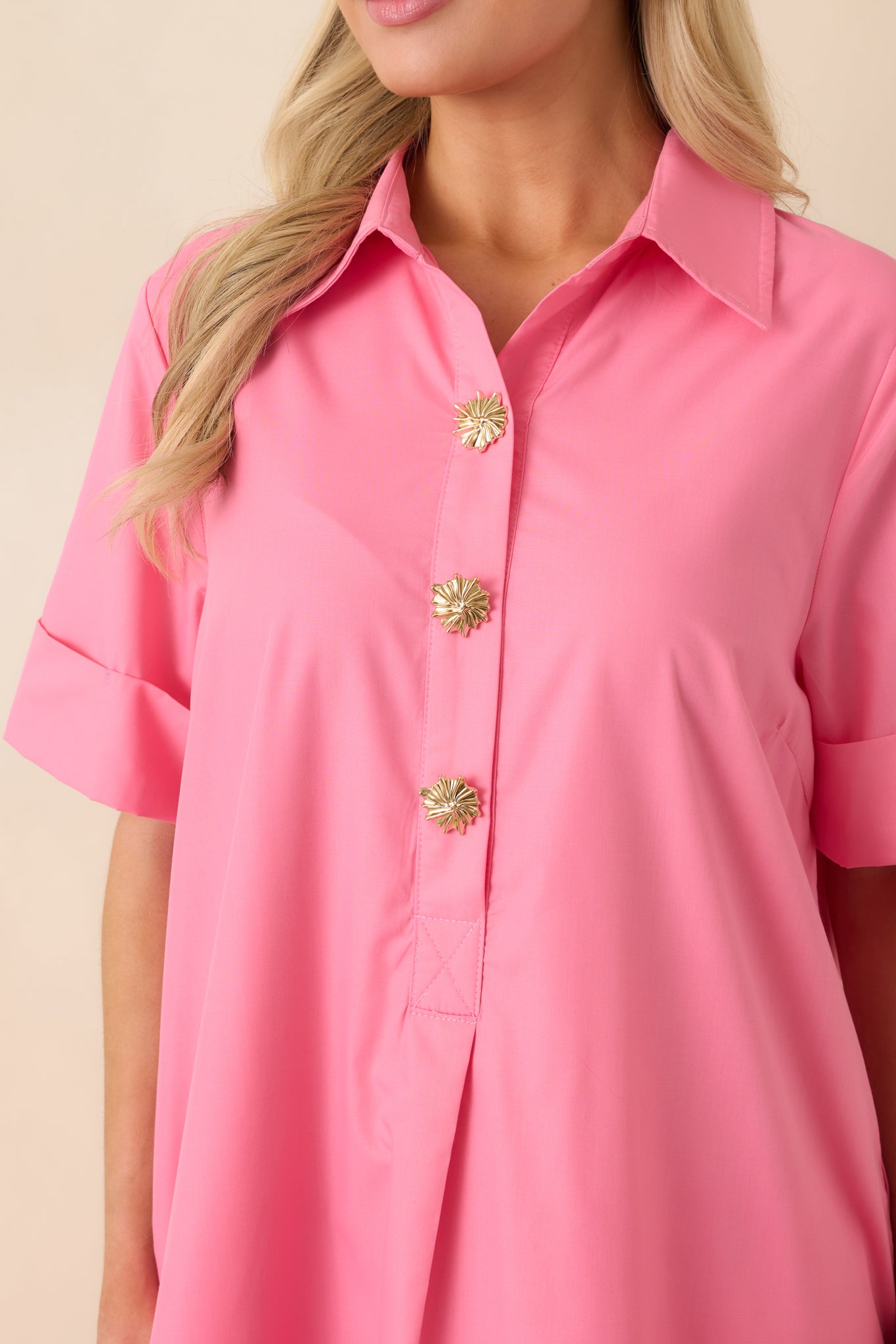 Close-up of the pink maxi dress highlighting the gold snap button hardware and fabric texture.