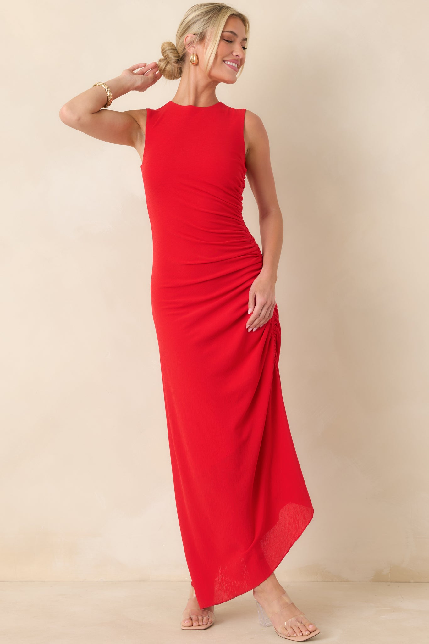 Red midi dress featuring sleek stretch fabric, sleeveless cut, and ruched sides that define the silhouette with modern simplicity.