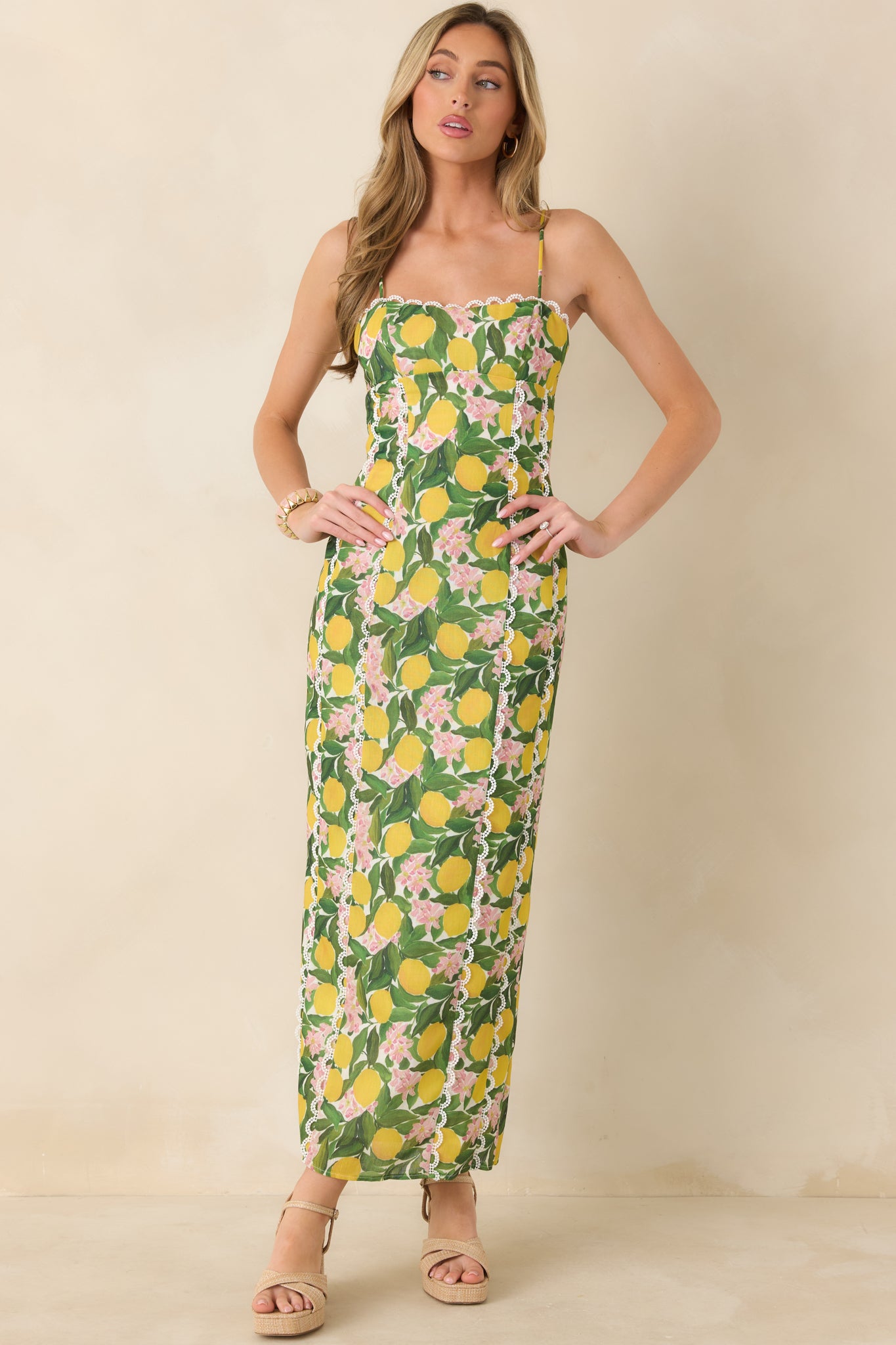 Yellow printed maxi dress designed with contrast lace along the neckline, slim adjustable straps, and a softly structured full-length shape.