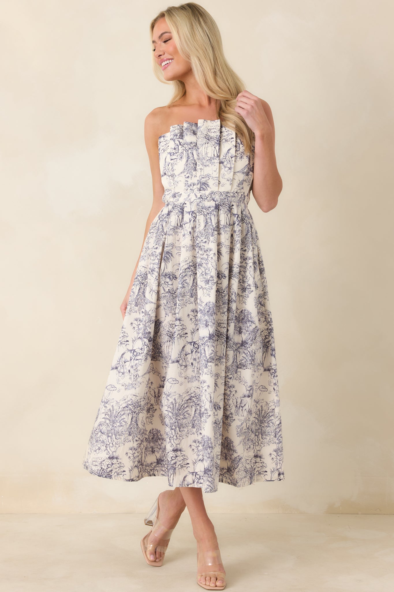 Blue toile midi dress featuring structured pleats and hidden hip pockets.