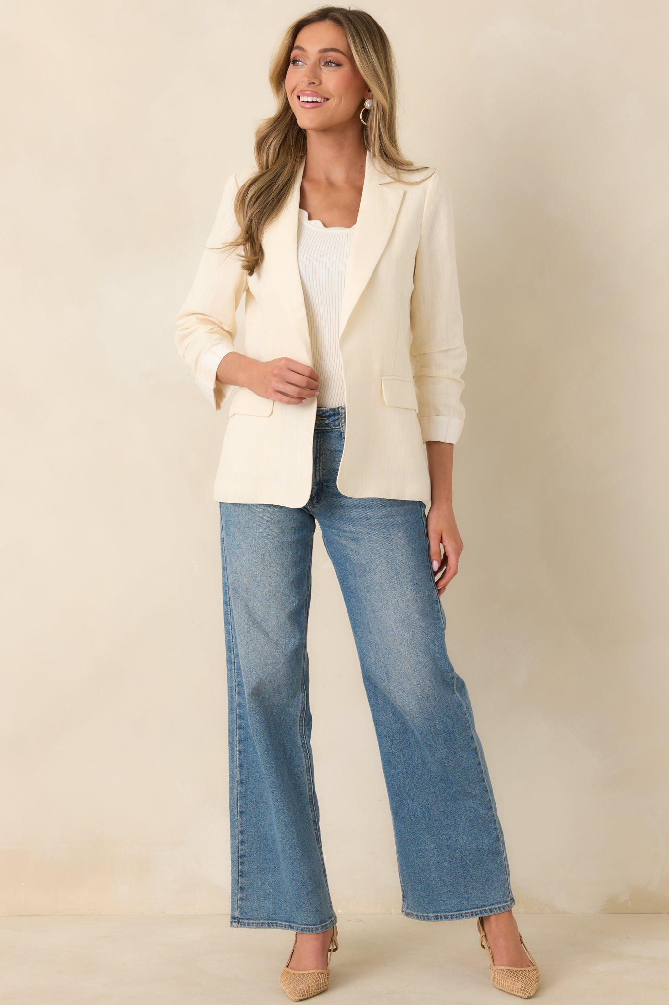 Ivory blazer with classic lapels, a streamlined silhouette, and ruched 3/4 sleeves for a polished yet relaxed look.