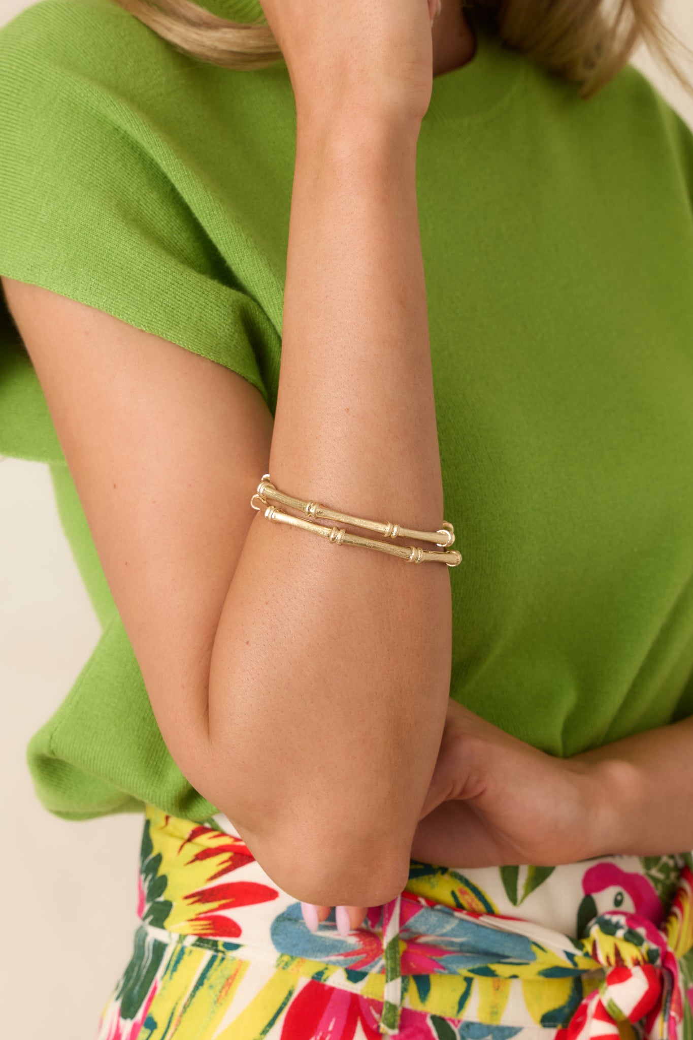 Close-up of dual gold bangles showing bamboo-inspired ridges, polished surface, and refined craftsmanship.