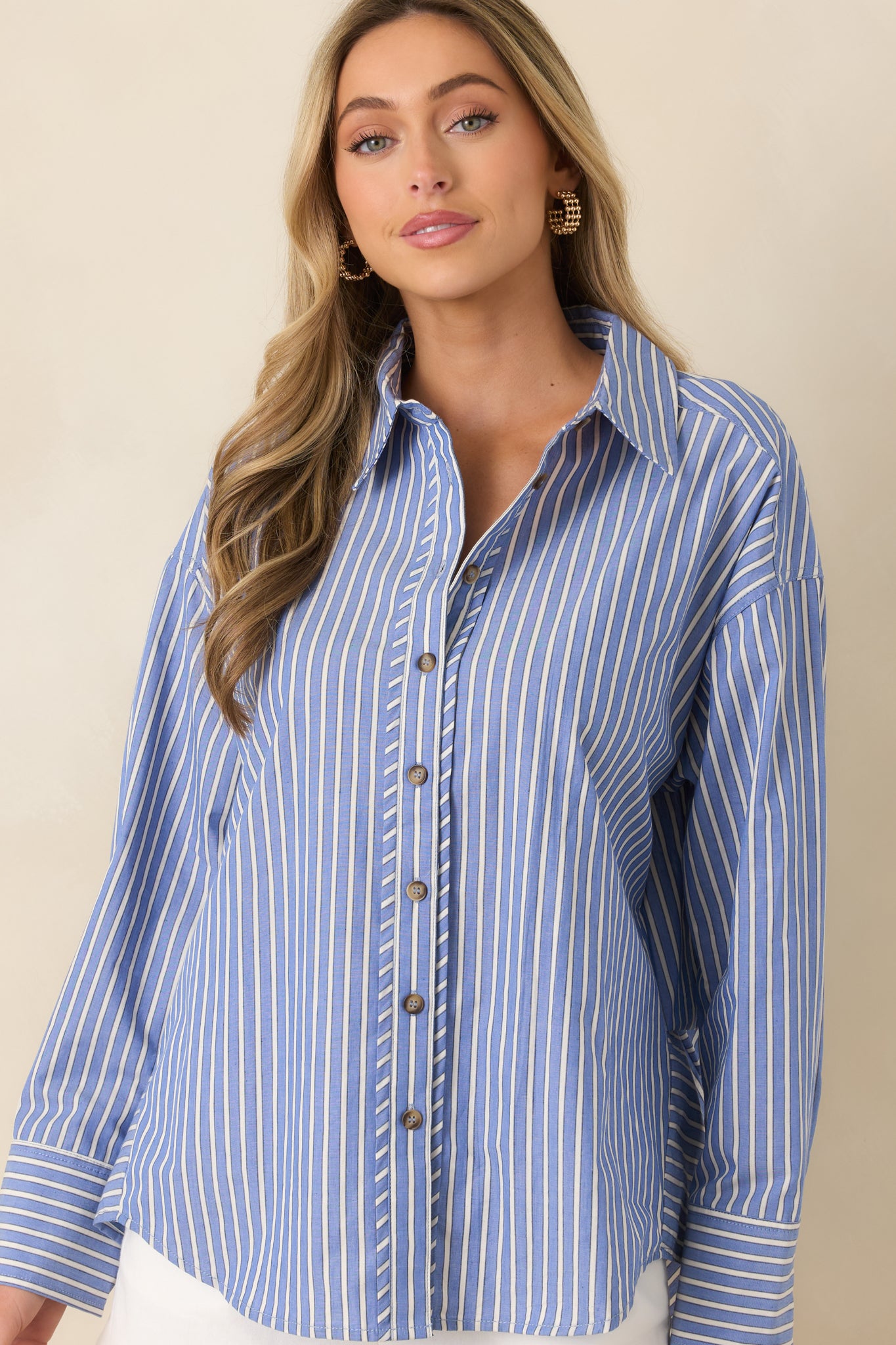 Cropped view emphasizing the scoop hem, sleeve length, and subtle stripe pattern on the shirt.