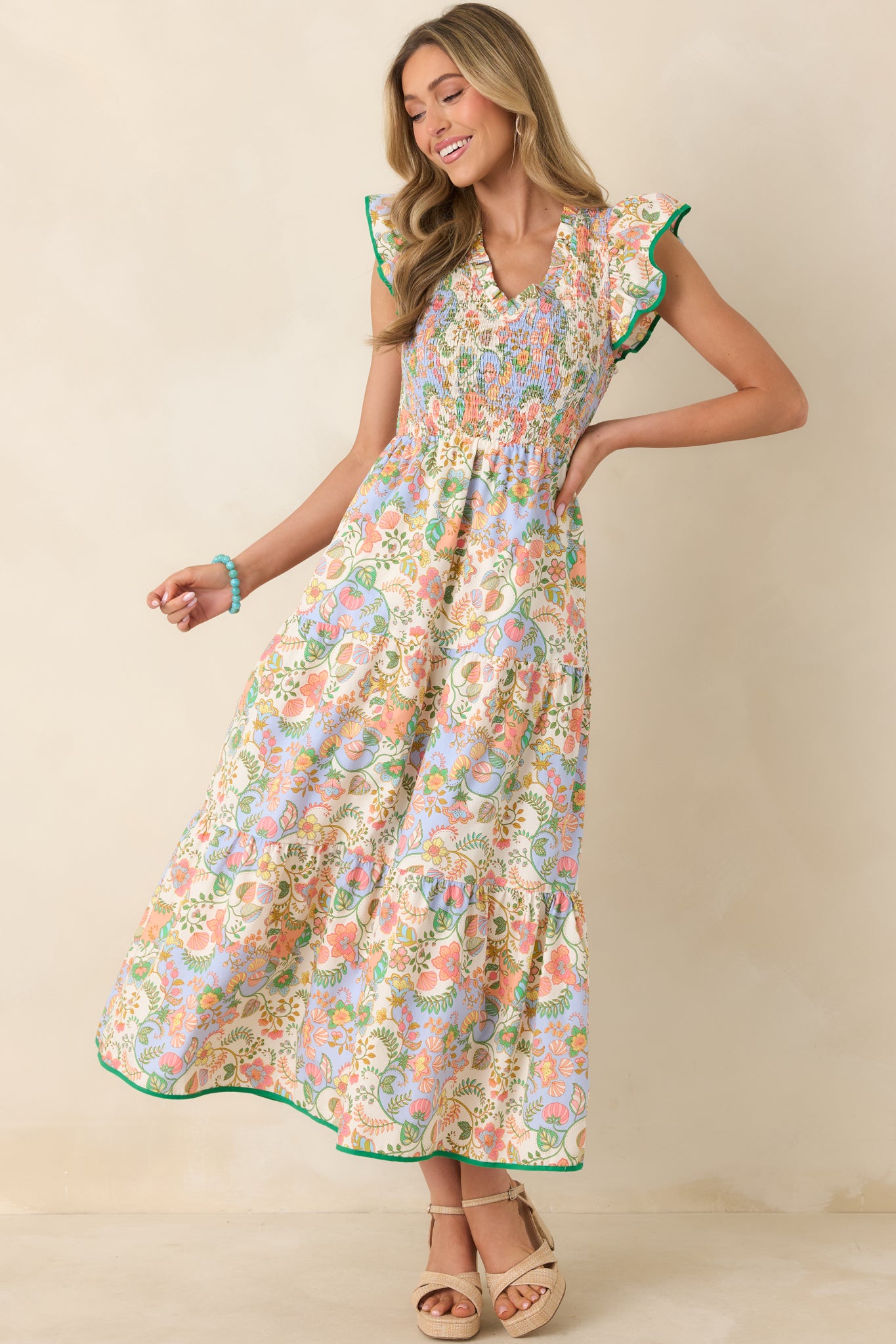 Colorful floral paisley maxi dress crafted from breathable cotton, designed with textured smocking through the bodice and soft ruffle cap sleeves above a breezy tiered silhouette.