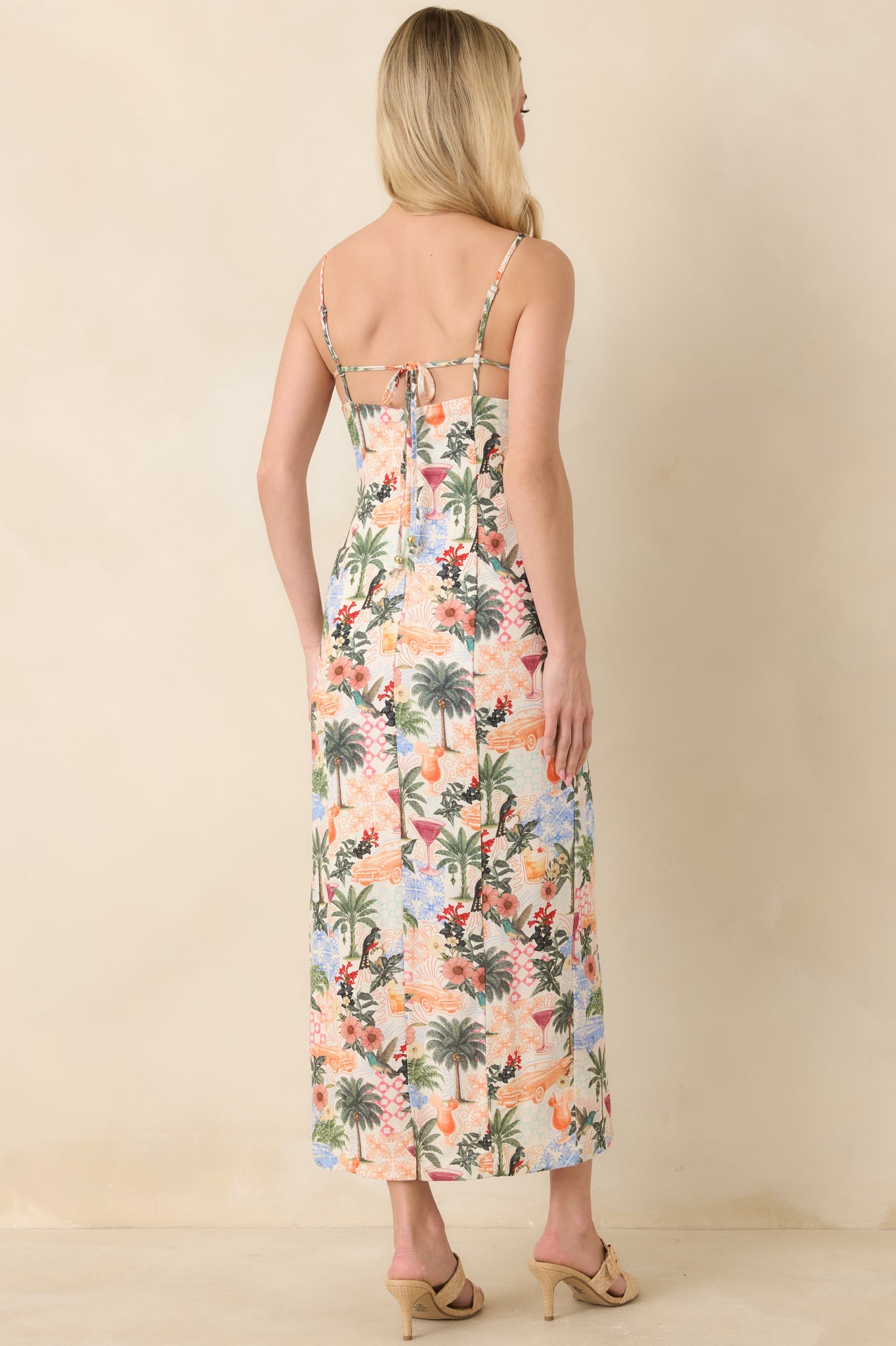 Rear view of tropical print midi dress with flowing skirt and delicate straps.
