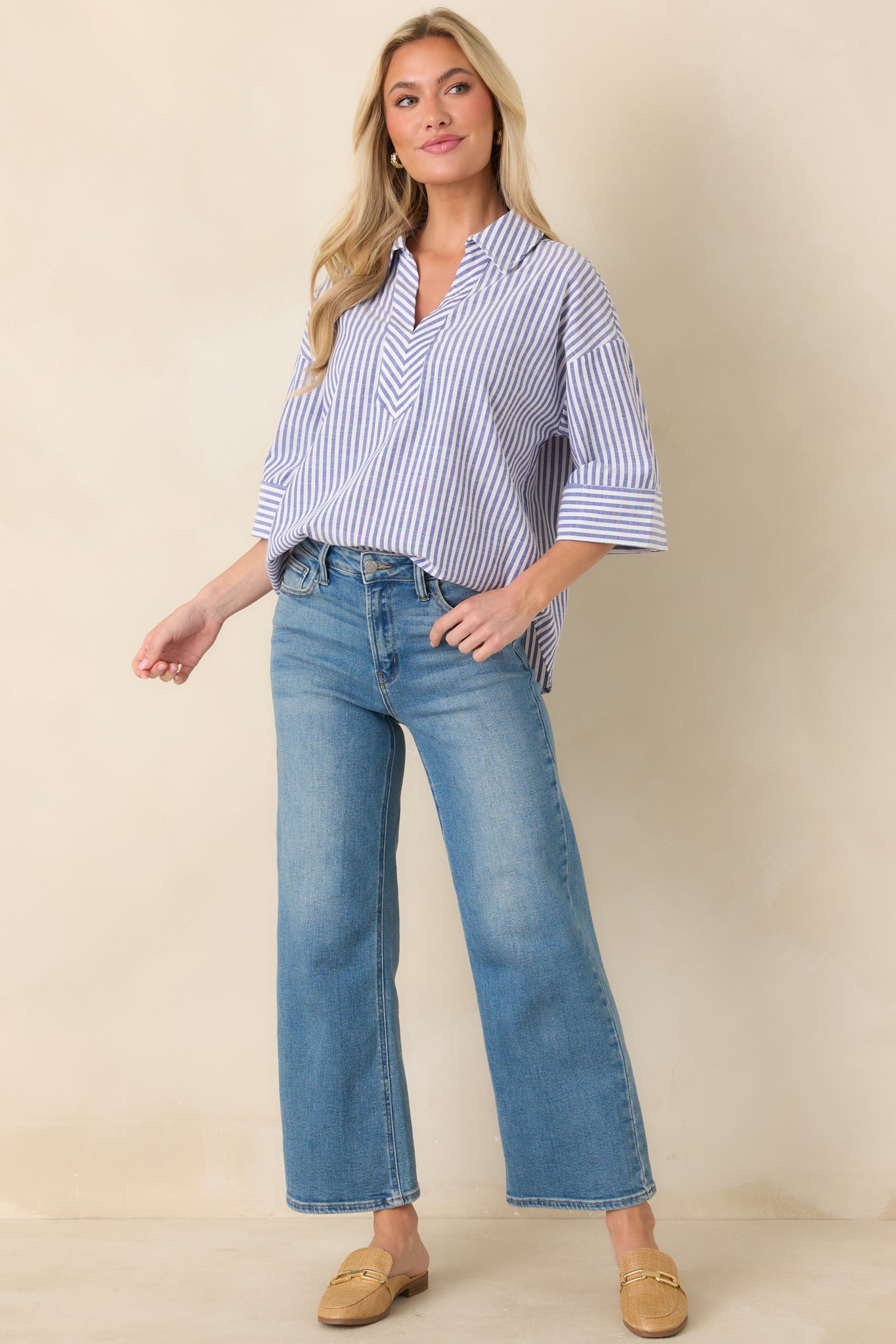 Full-body view of blue and white vertical stripe blouse with a structured collar and split V-neckline.