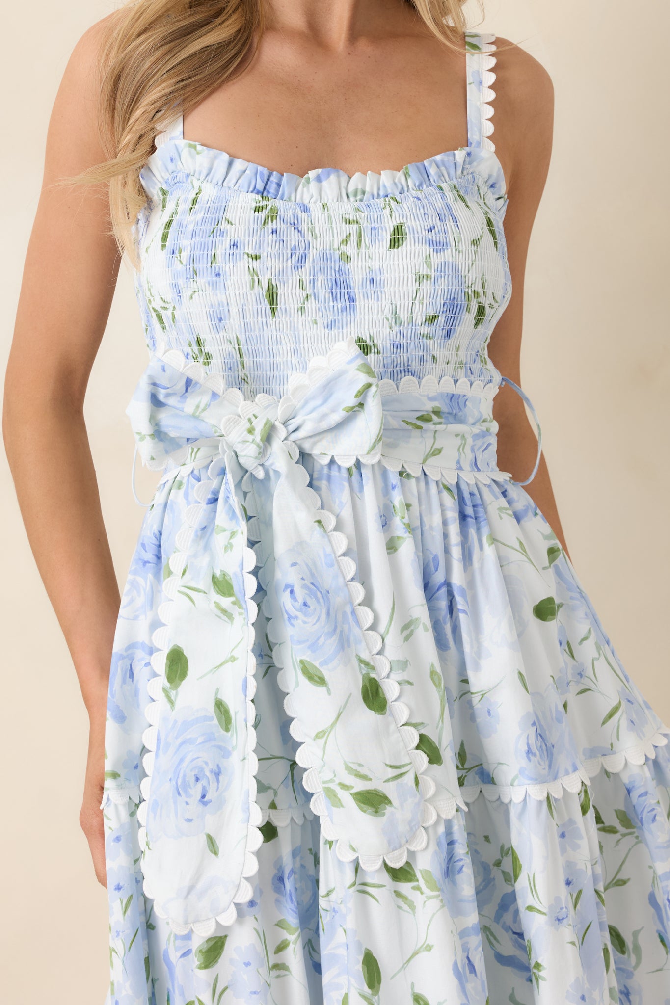 Close-up of smocked bodice, scalloped trim on adjustable straps, and self-tie waist belt.