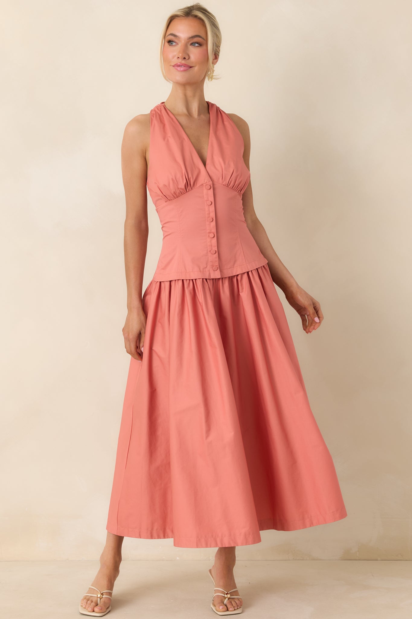 Sleeveless cotton midi dress with structured bodice and V-neckline.