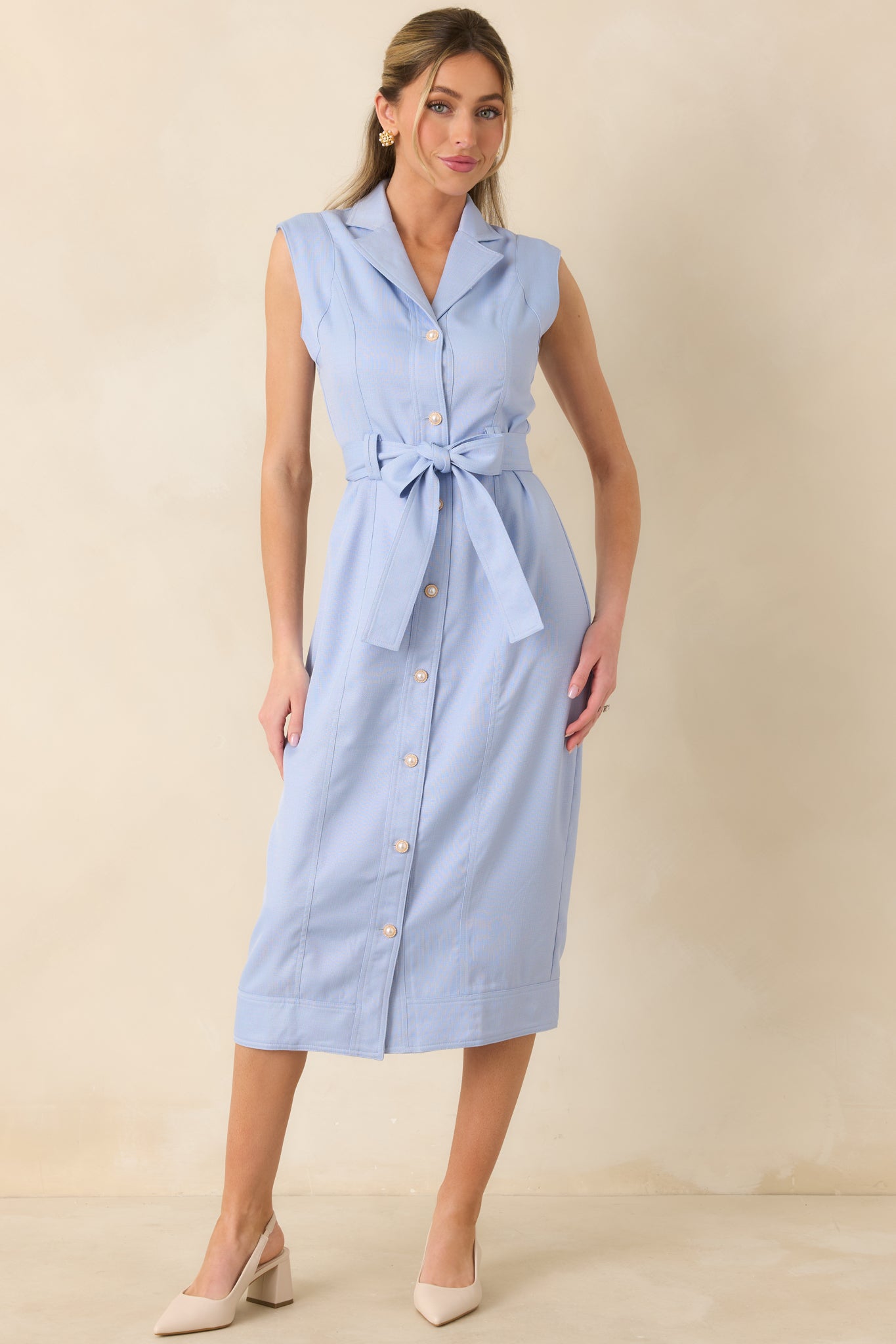 Structured blue midi dress with sleeveless design, front button closure, and self-tie belt creating a refined, versatile shape.
