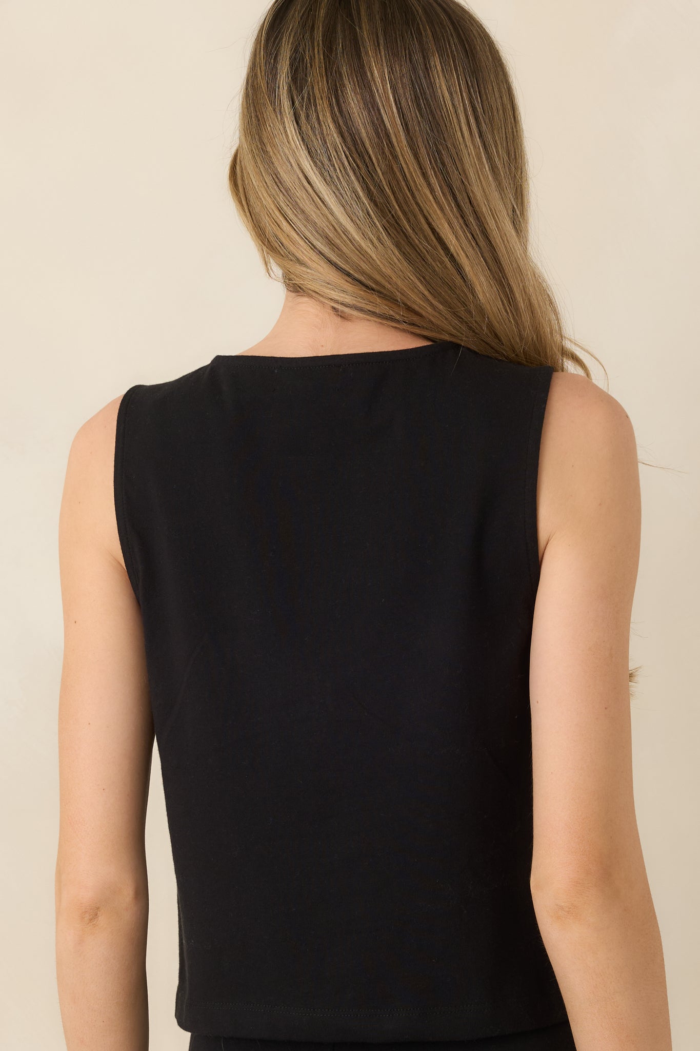 Rear view of sleeveless top featuring a clean, relaxed silhouette with a smooth, lightweight finish.