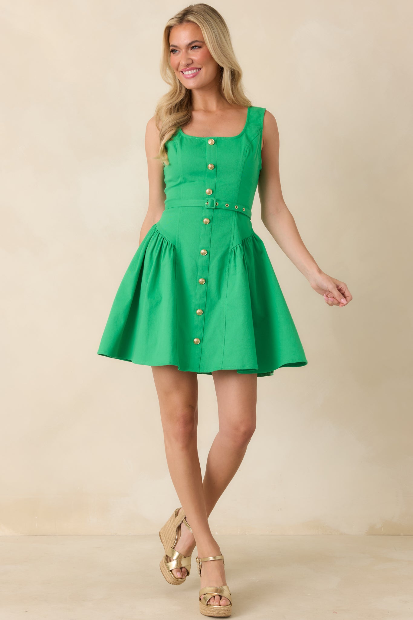 Sleeveless mini featuring a coordinating tie belt and softly gathered drop-waist skirt.