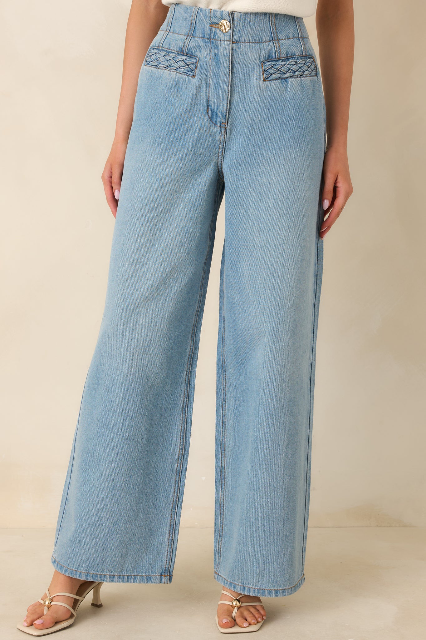 Closer view of the high-rise waistband and front pockets, highlighting the relaxed straight-leg shape and soft denim texture.