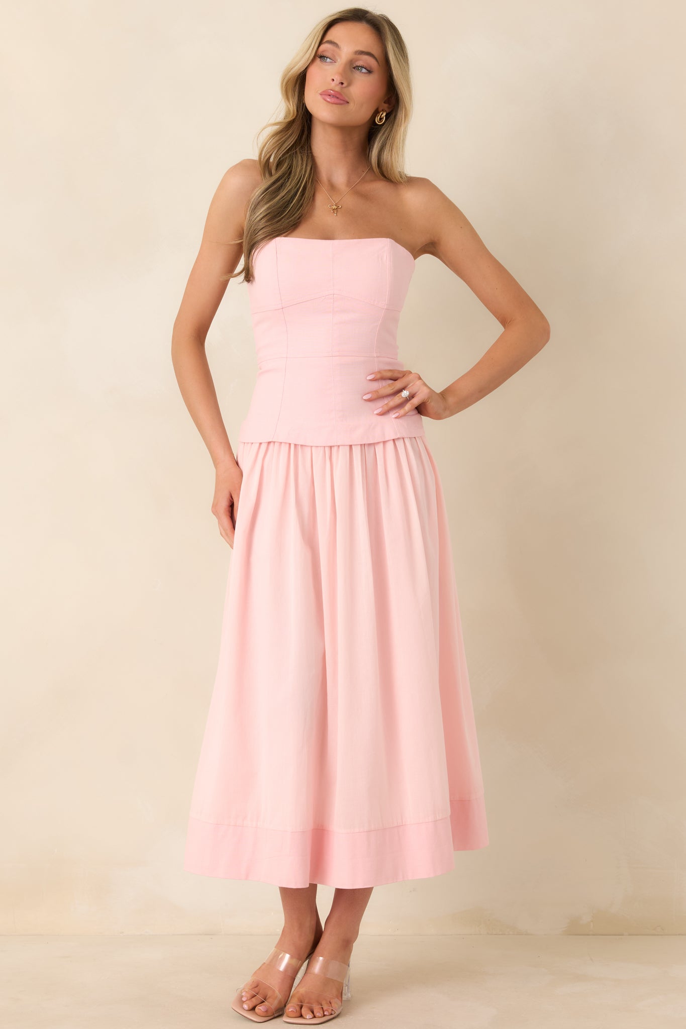 Elegant midi dress showcasing a fitted bustier-style bodice, adjustable straps, and a flowing skirt with functional pockets.