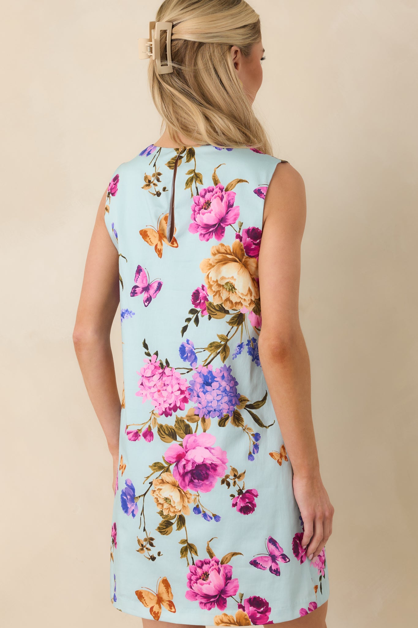 Back view of the sleeveless cotton dress displaying the keyhole button closure and smooth straight silhouette.