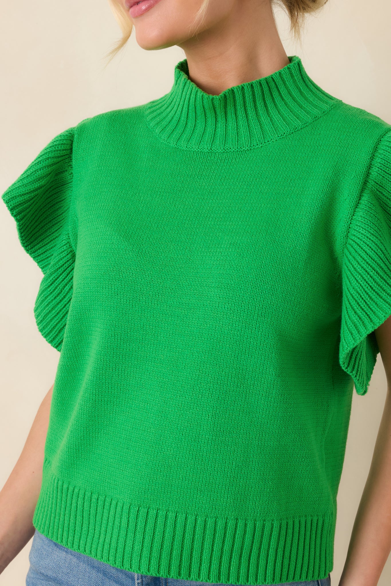 Close-up of the soft knit fabrication showcasing the ribbed mock neckline and textured stitching.