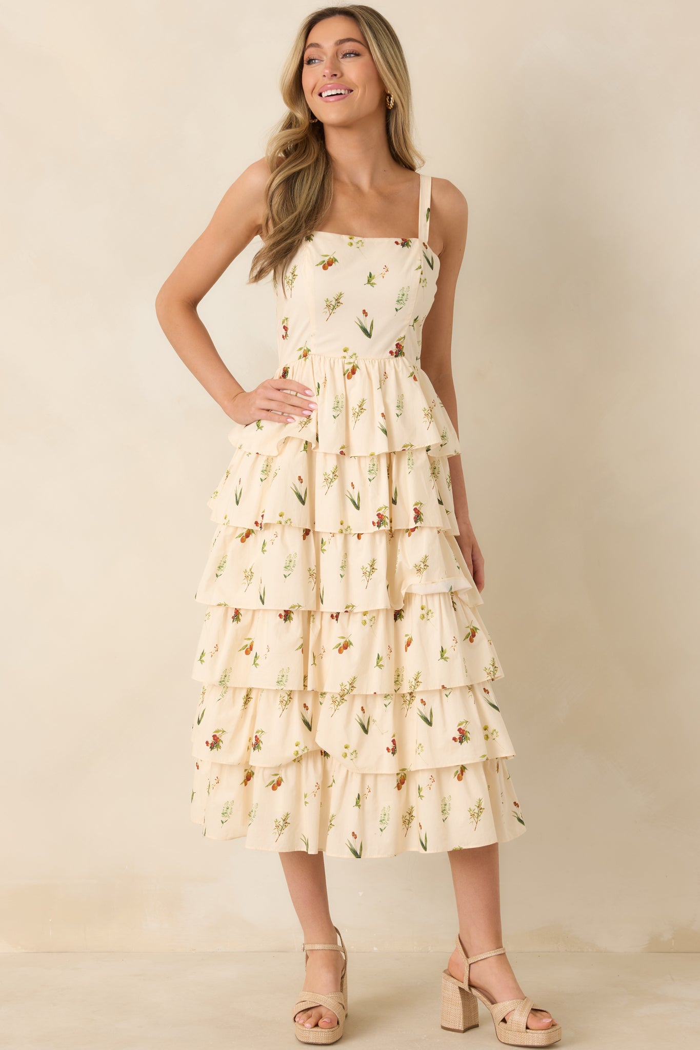 Ivory sleeveless dress with colorful floral pattern, structured paneling, and midi-length silhouette.