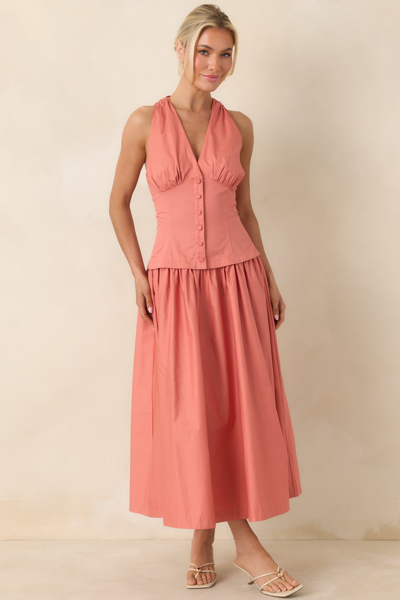 V-neck midi dress with structured shape and polished button accents.