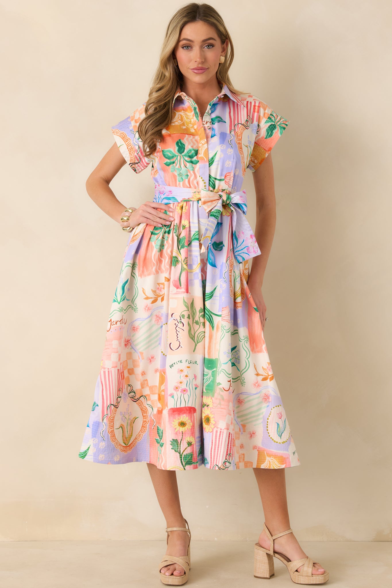 Breathable cotton midi dress in a mixed floral pattern with collar detail, waist tie accent, and flowing skirt shape.