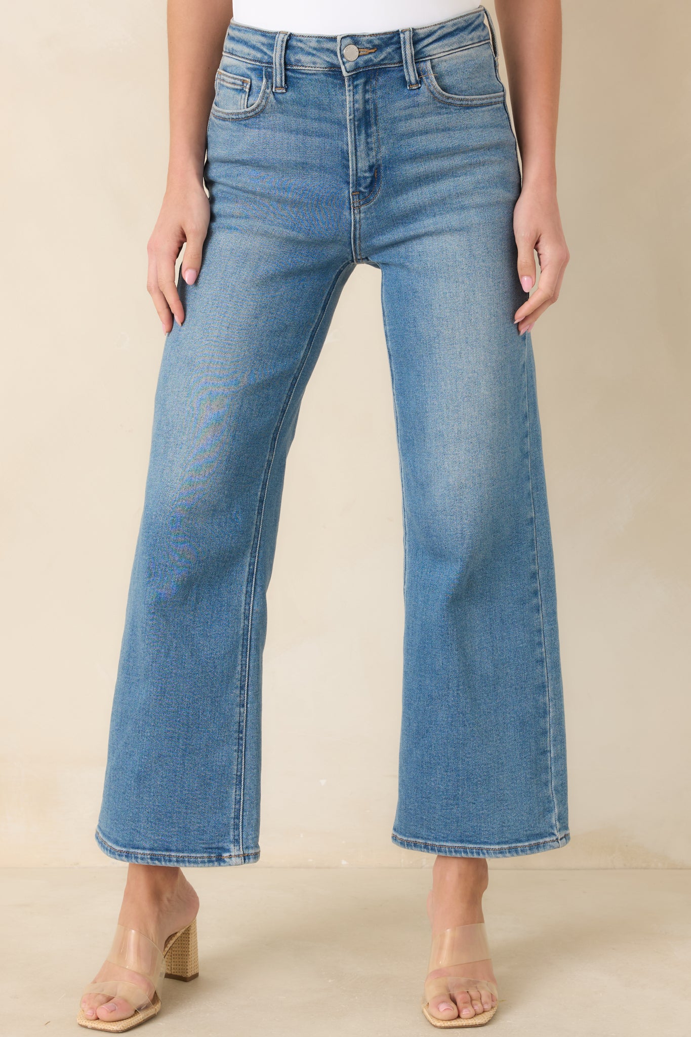 Light wash wide leg jeans with a cropped length and structured waistband detail.