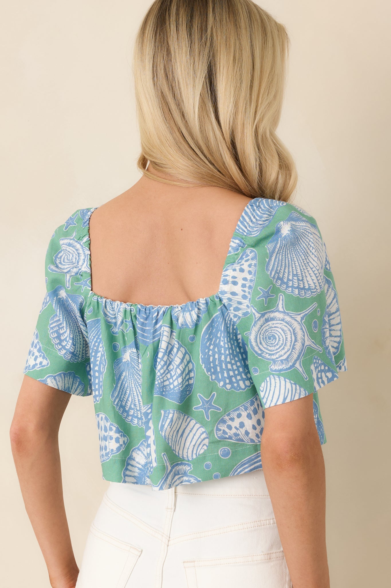 Back view of the green cropped top displaying the relaxed fit and flowing back silhouette.