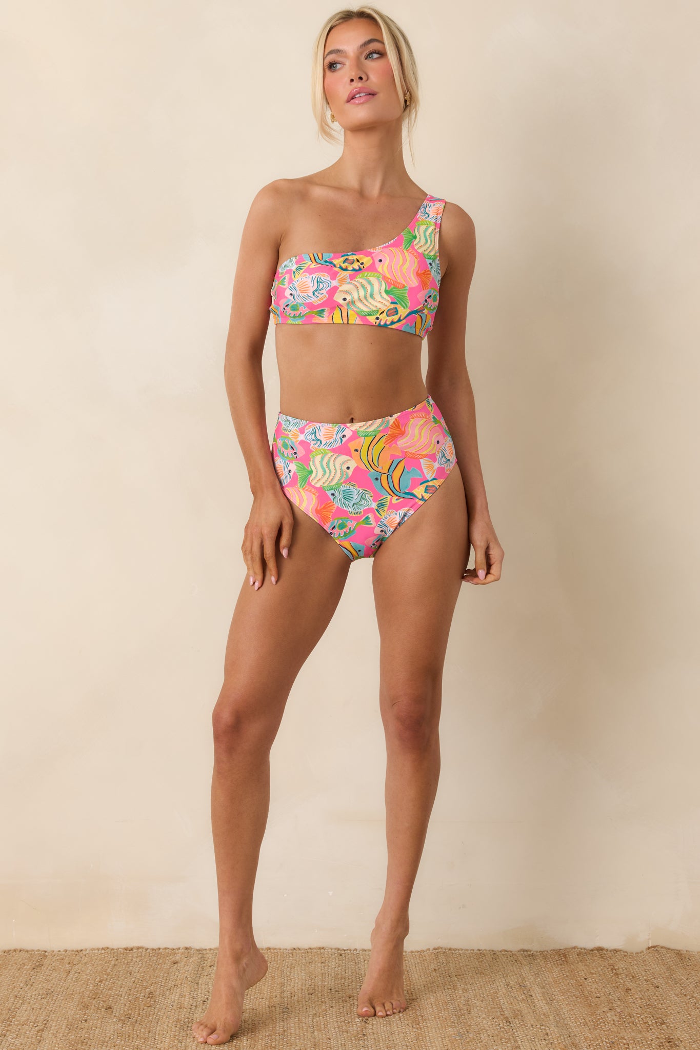 High-waisted bikini bottoms with a vibrant pink background, featuring colorful fish and ocean-inspired print for a tropical look.