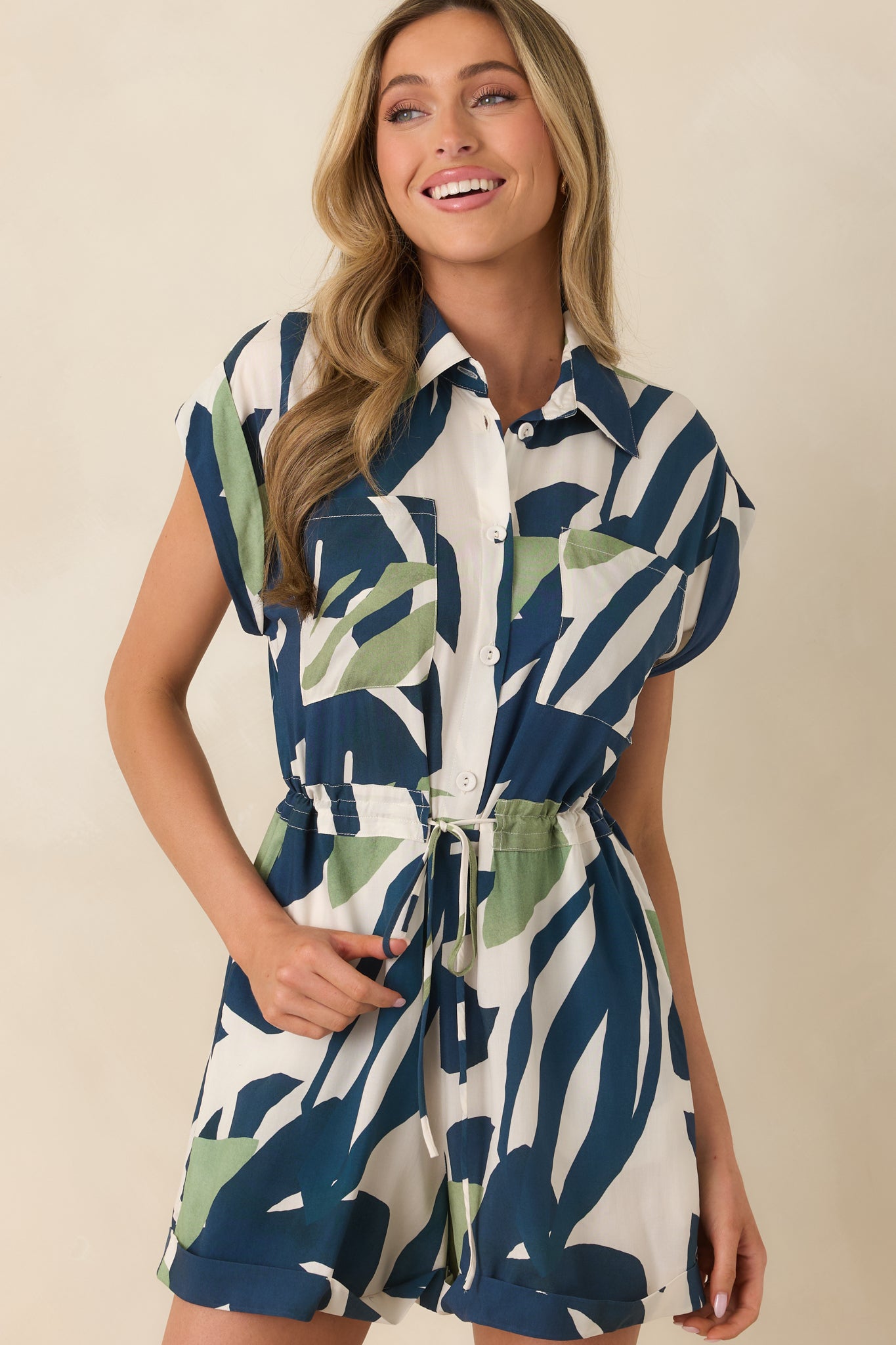 Closer view of the collared neckline and button-front detailing, highlighting the tropical palm leaf pattern.