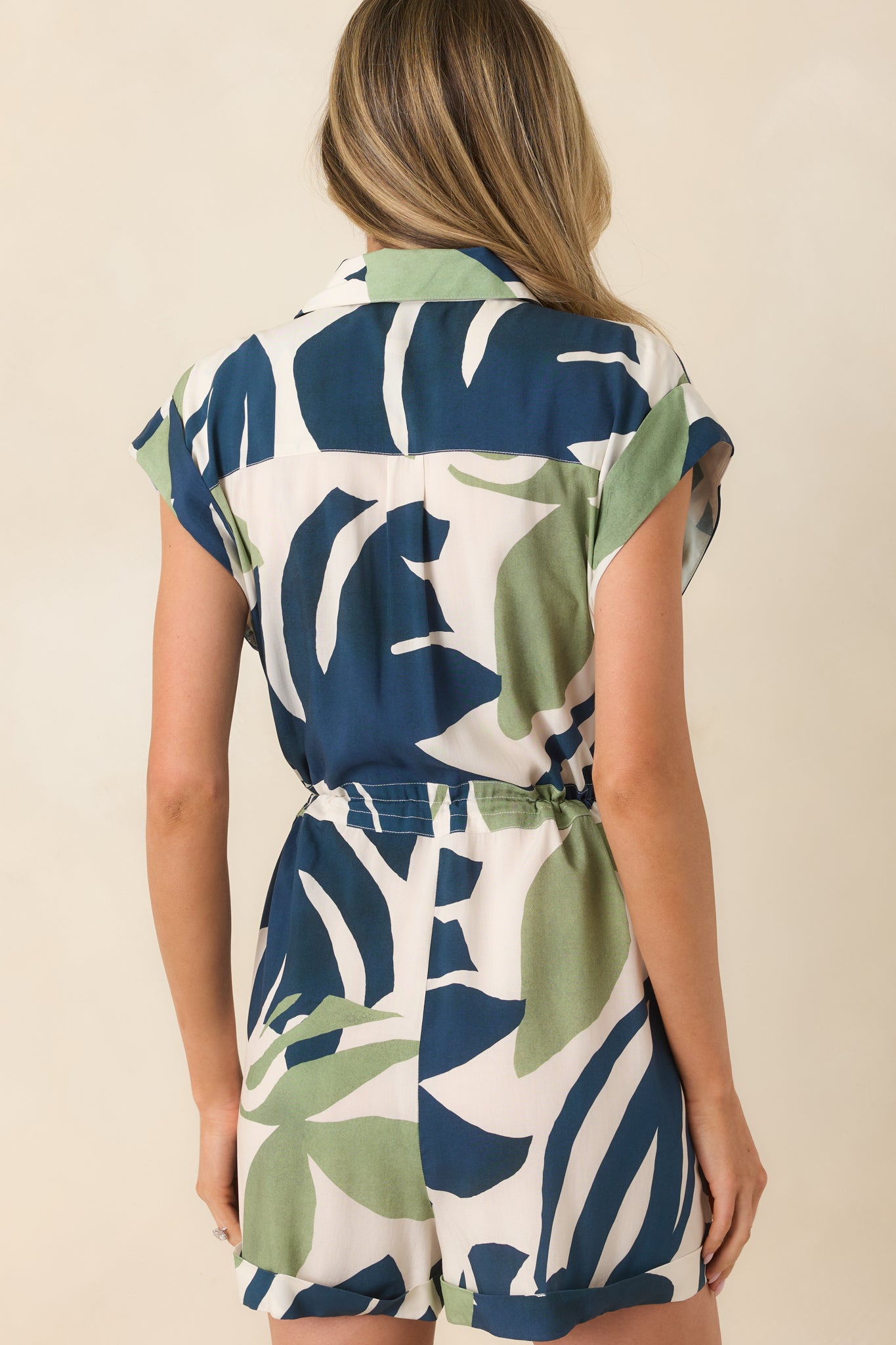 Rear view of the romper showing the clean cut of the back, relaxed silhouette, and cuffed hem finish on the shorts.