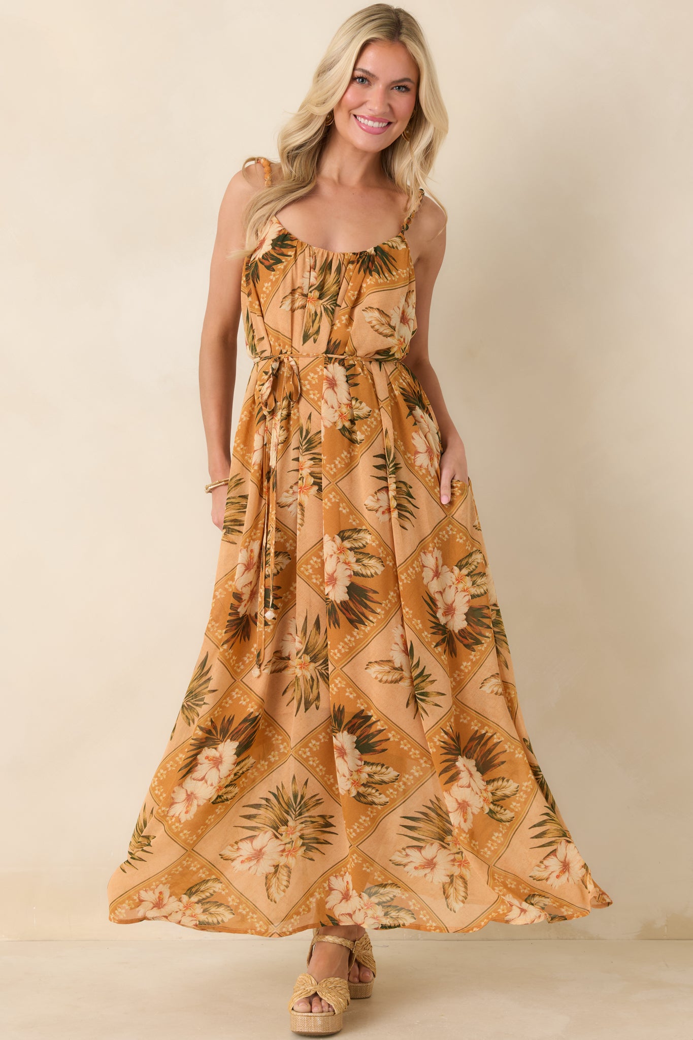 Full-length front shot of a tropical print maxi dress featuring a self-tie waist and breezy, full-length skirt.