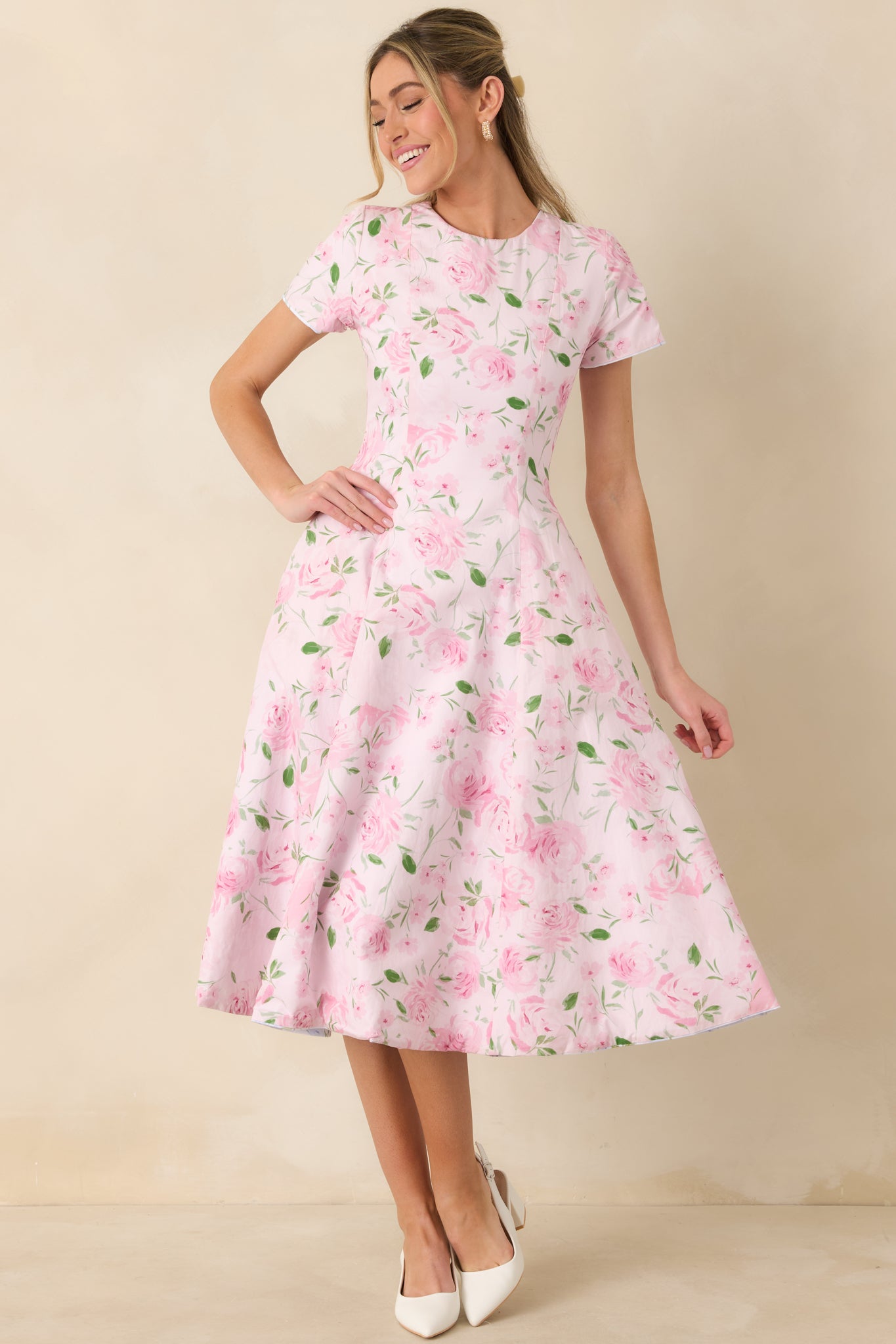 Pink floral midi dress featuring a gently contoured bodice and classic midi-length silhouette.
