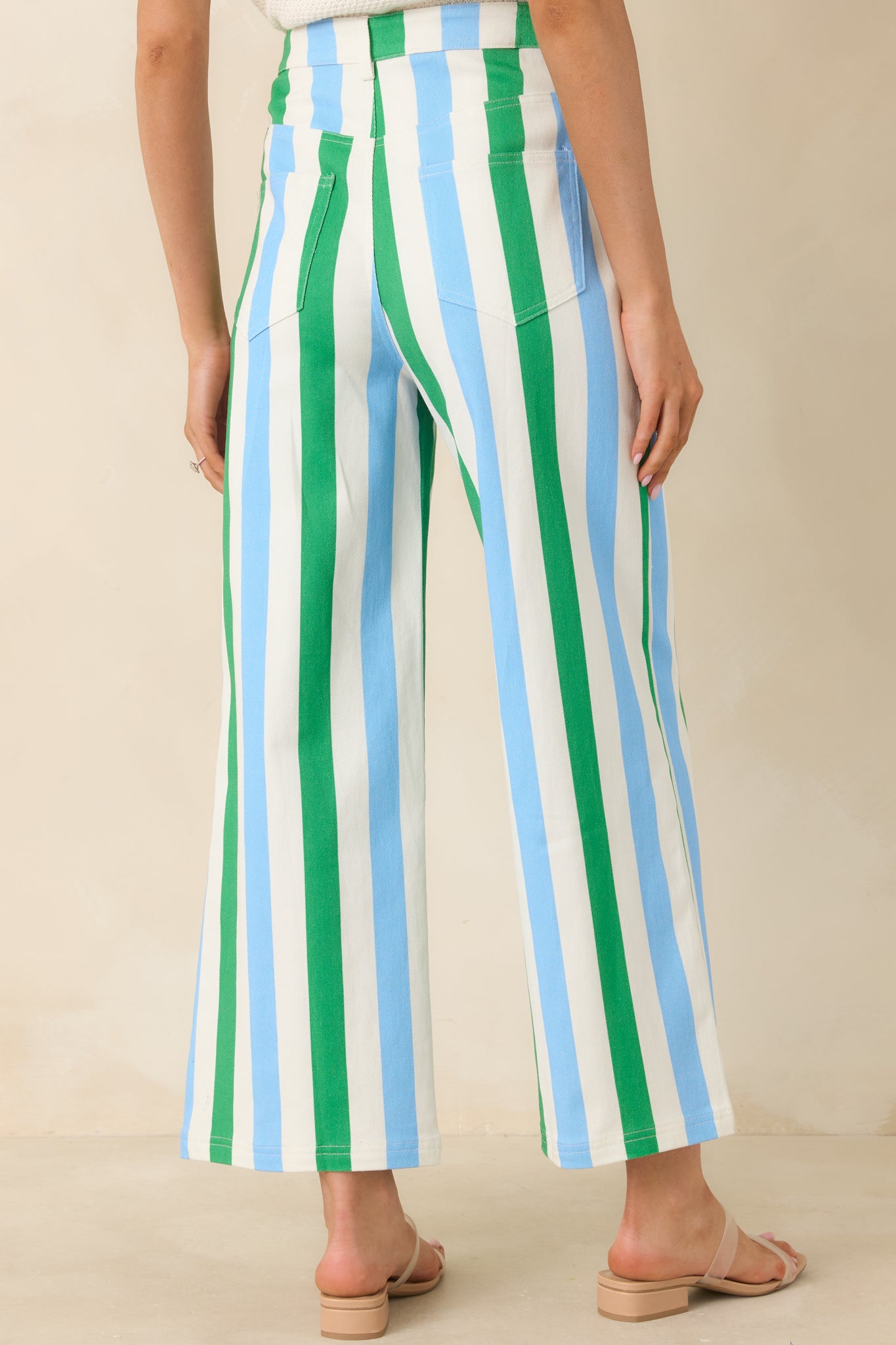 Rear view of green, blue, and white striped pants featuring a high-rise waist, wide leg silhouette, and clean vertical stripe design.