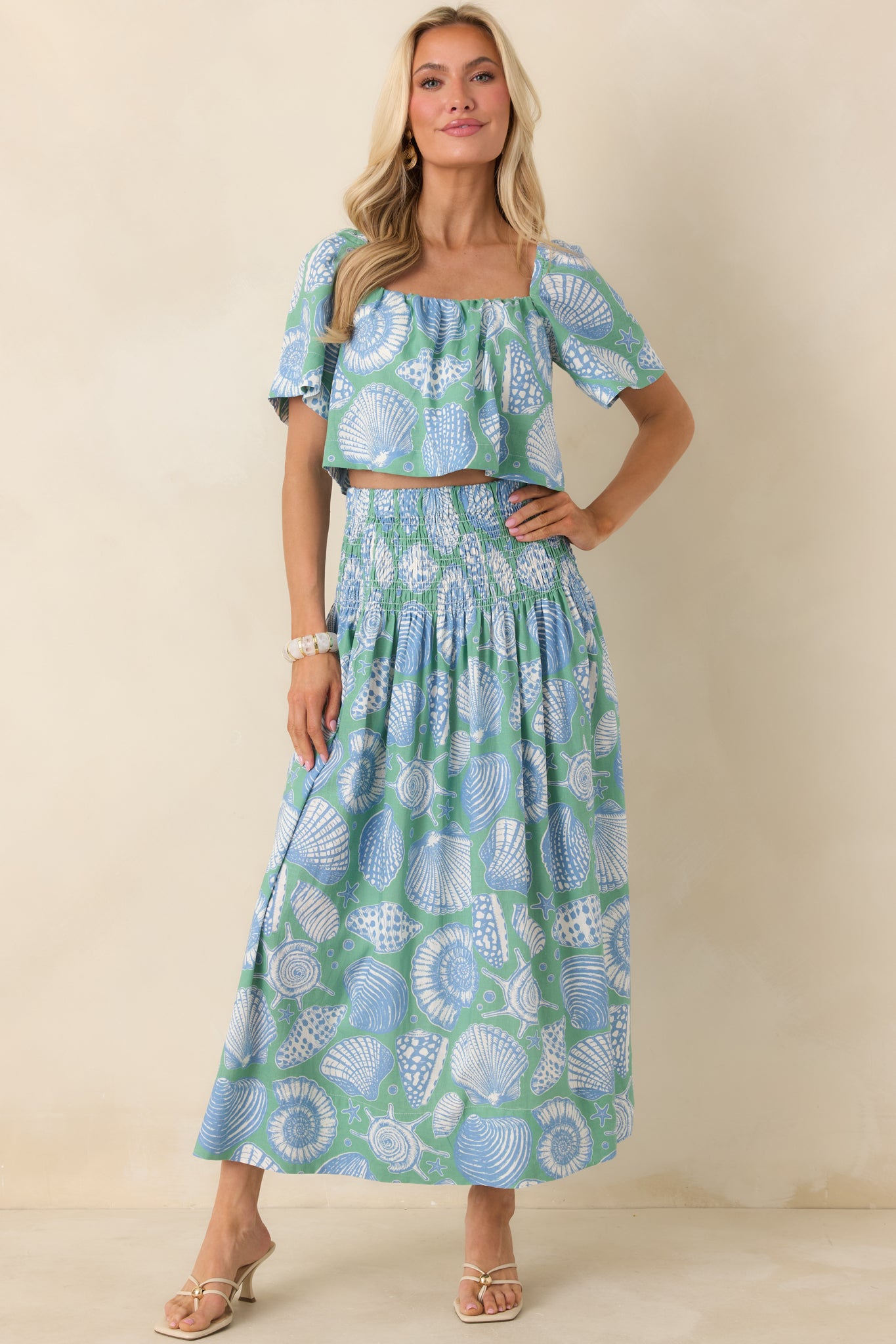 Another full-body image of the skirt showcasing an oversized shell print motif in soft blue and ivory colors.
