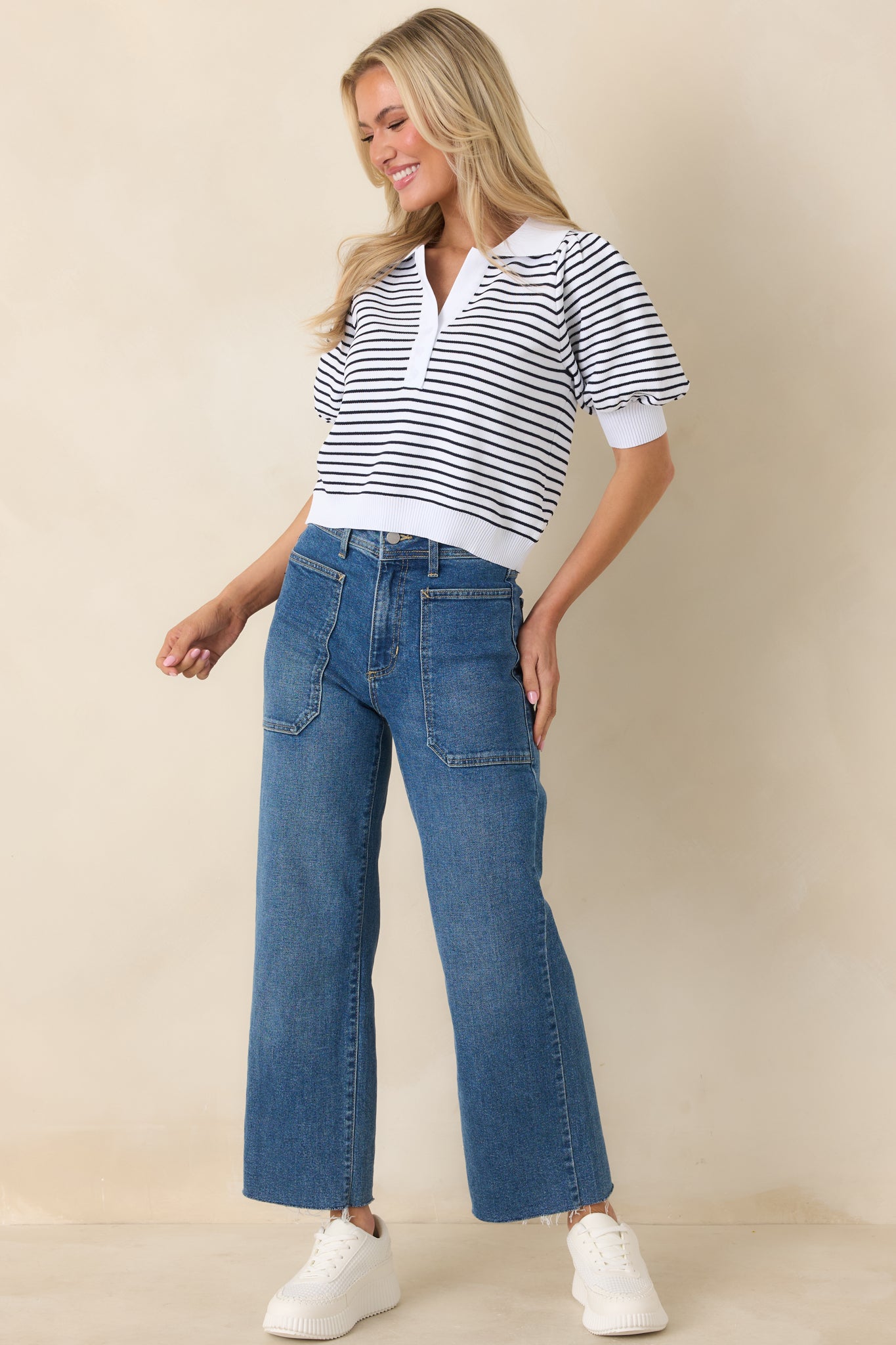 Classic striped knit polo top with collared neckline, partial button-front closure, and subtle puff sleeve detailing.