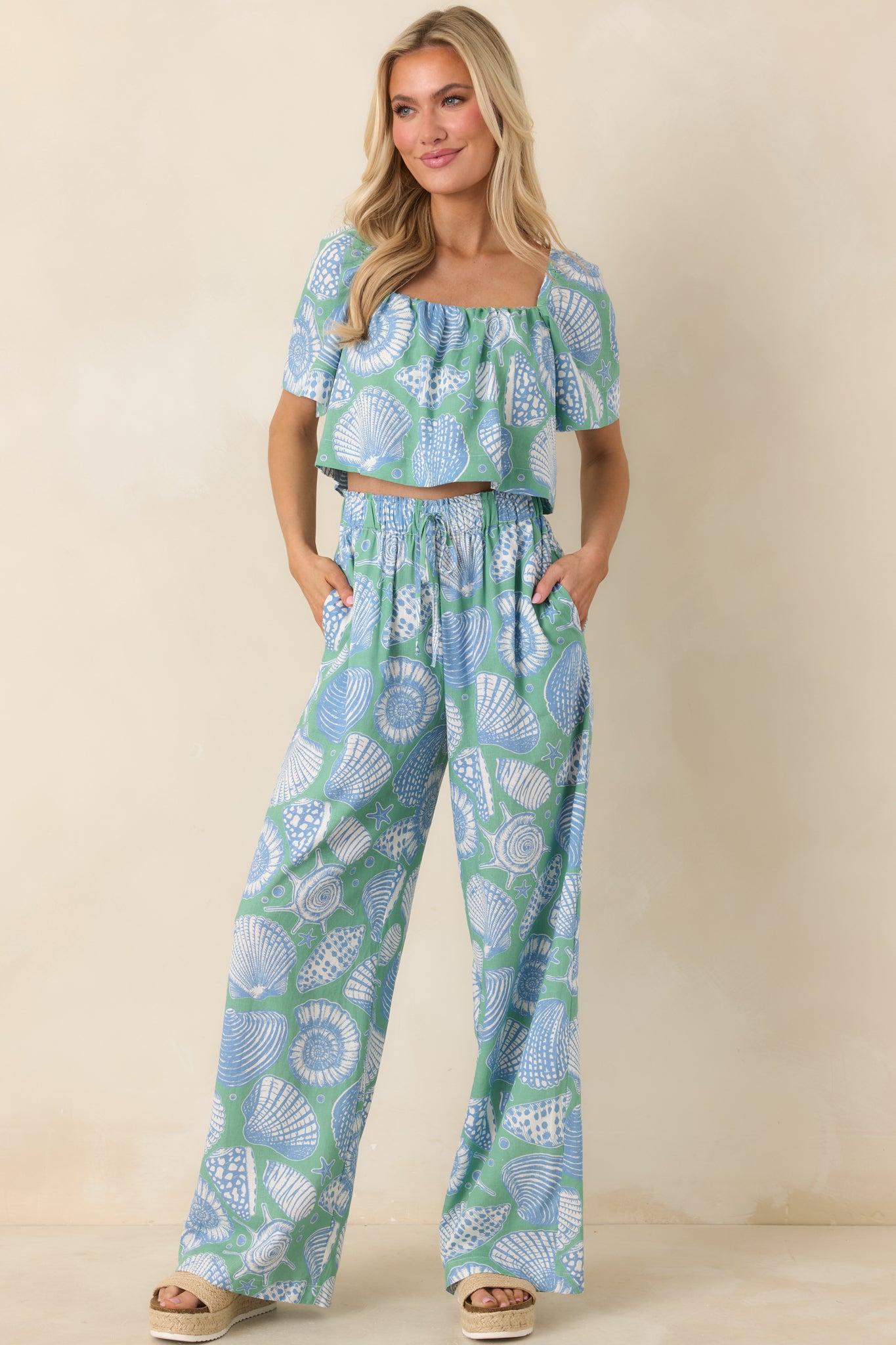 Green multi wide leg pants with a vintage seaside-inspired shell print and flowy full-length shape.