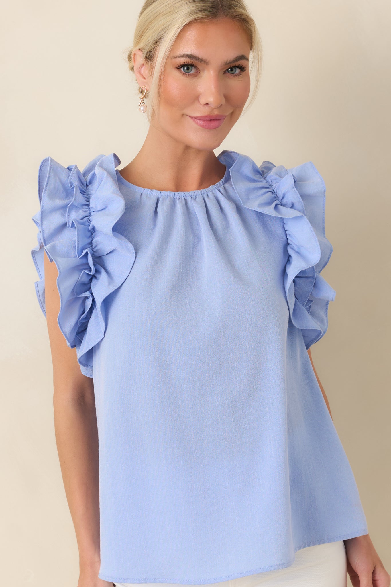 Ruffled shoulder detailing adding soft texture to light blue fabric.