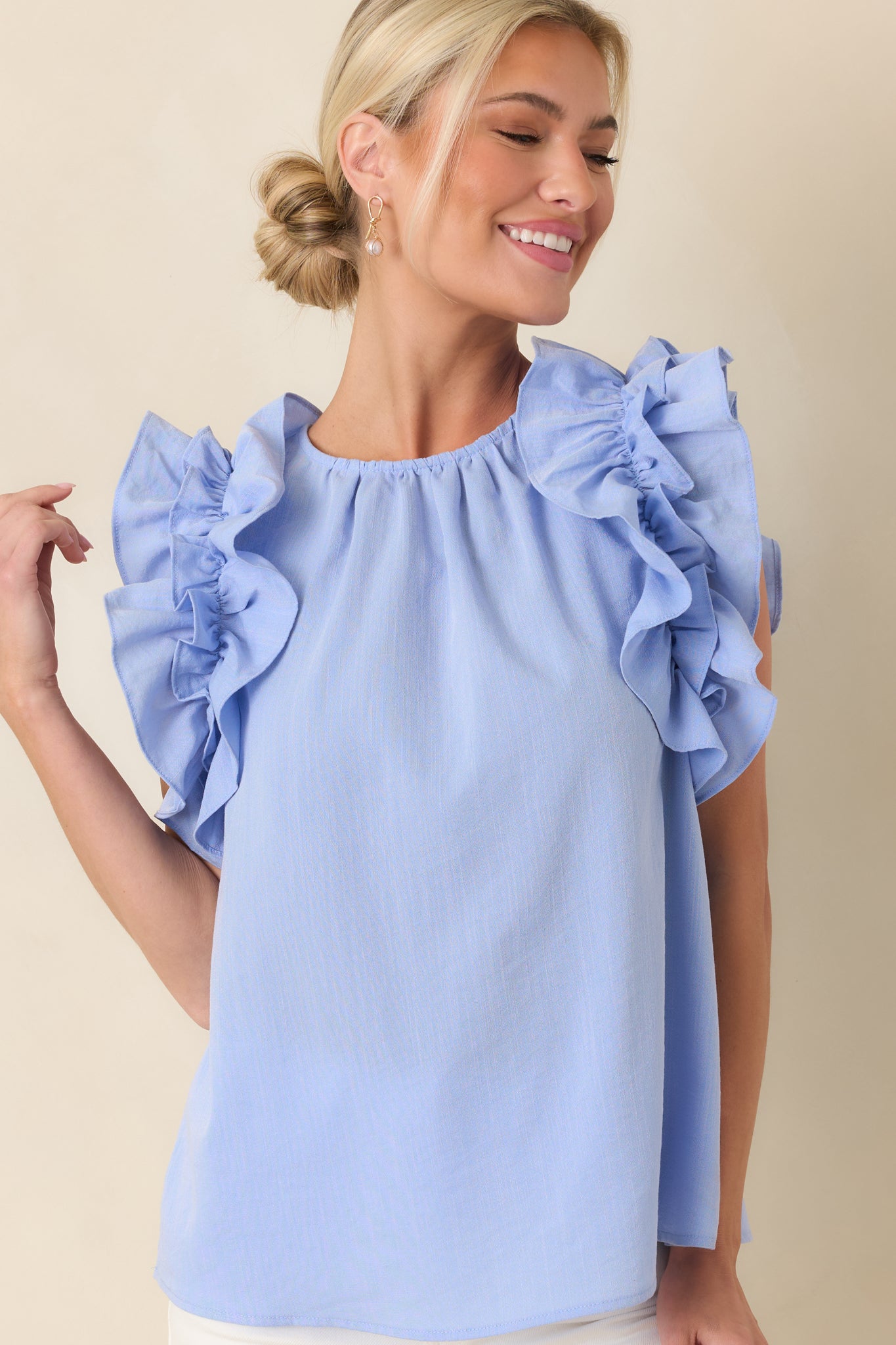 Light blue fabric highlighting smooth construction and structured neckline.