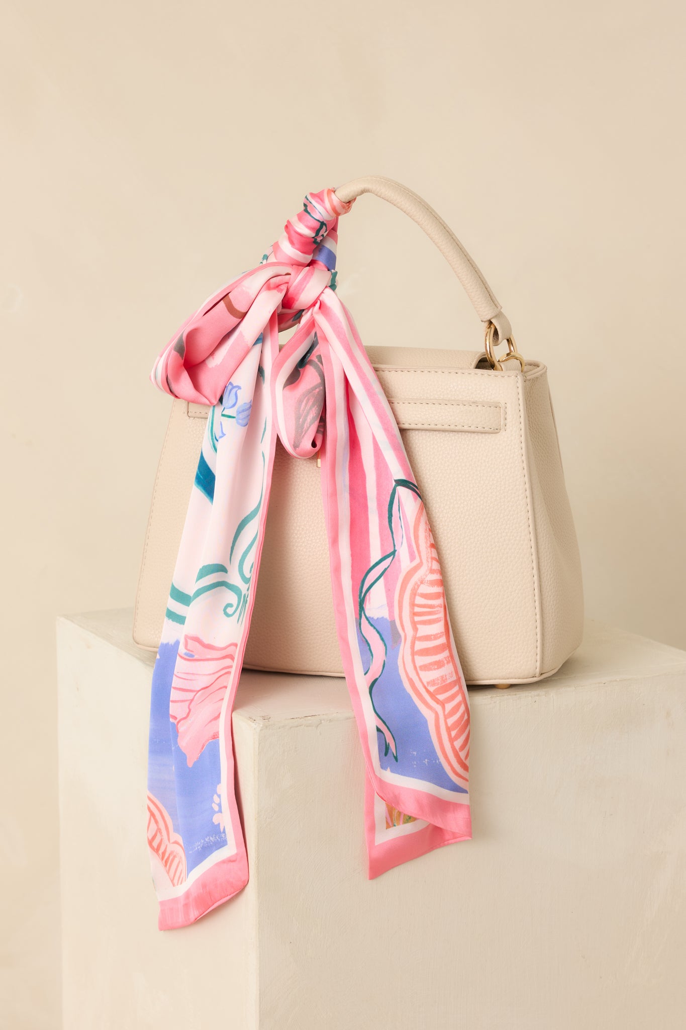 Cropped view focusing on the peach tones and subtle multicolor accents along the twilly scarf.