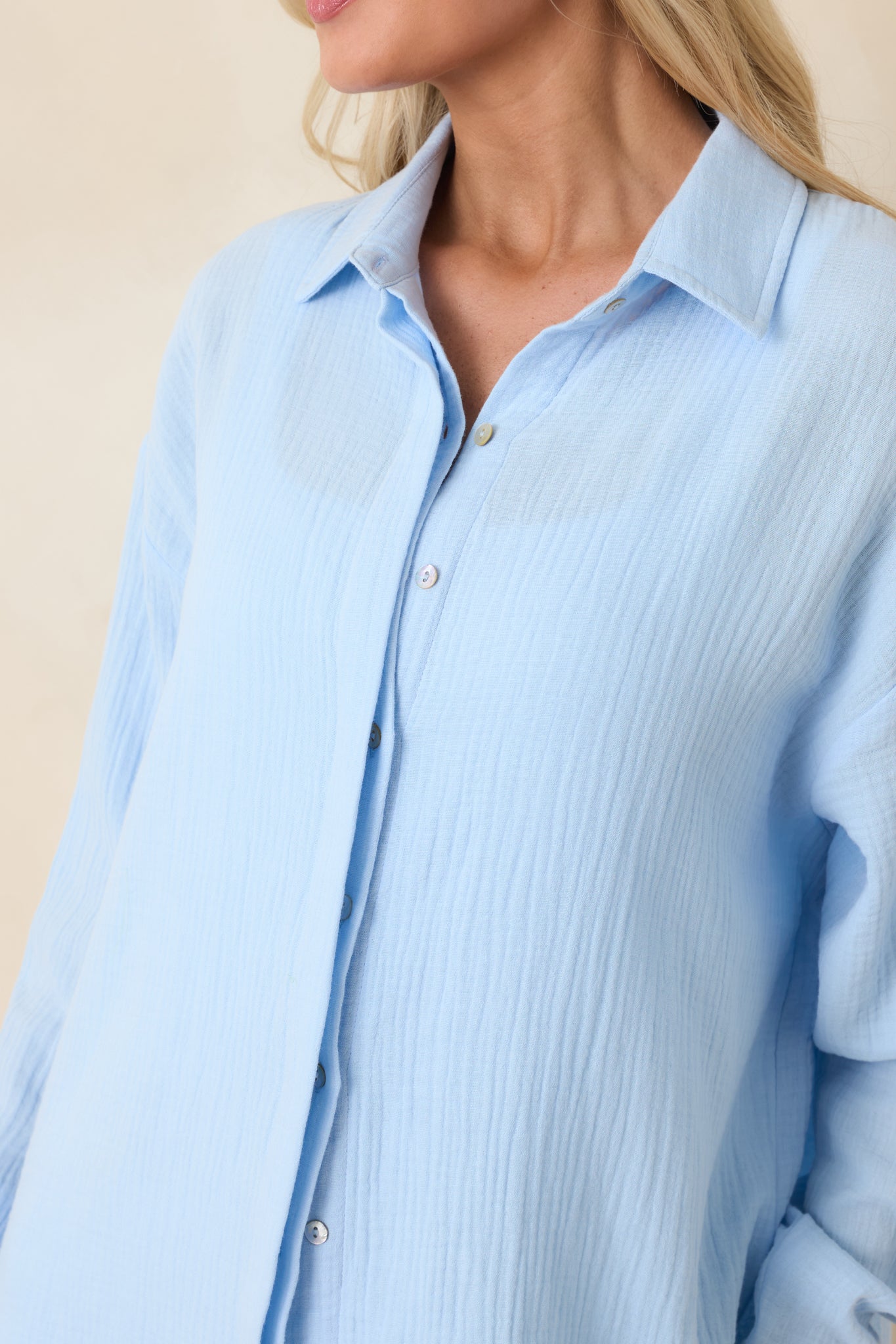 Textured lightweight cotton fabric with front button closure and buttoned cuff on blue shirt.