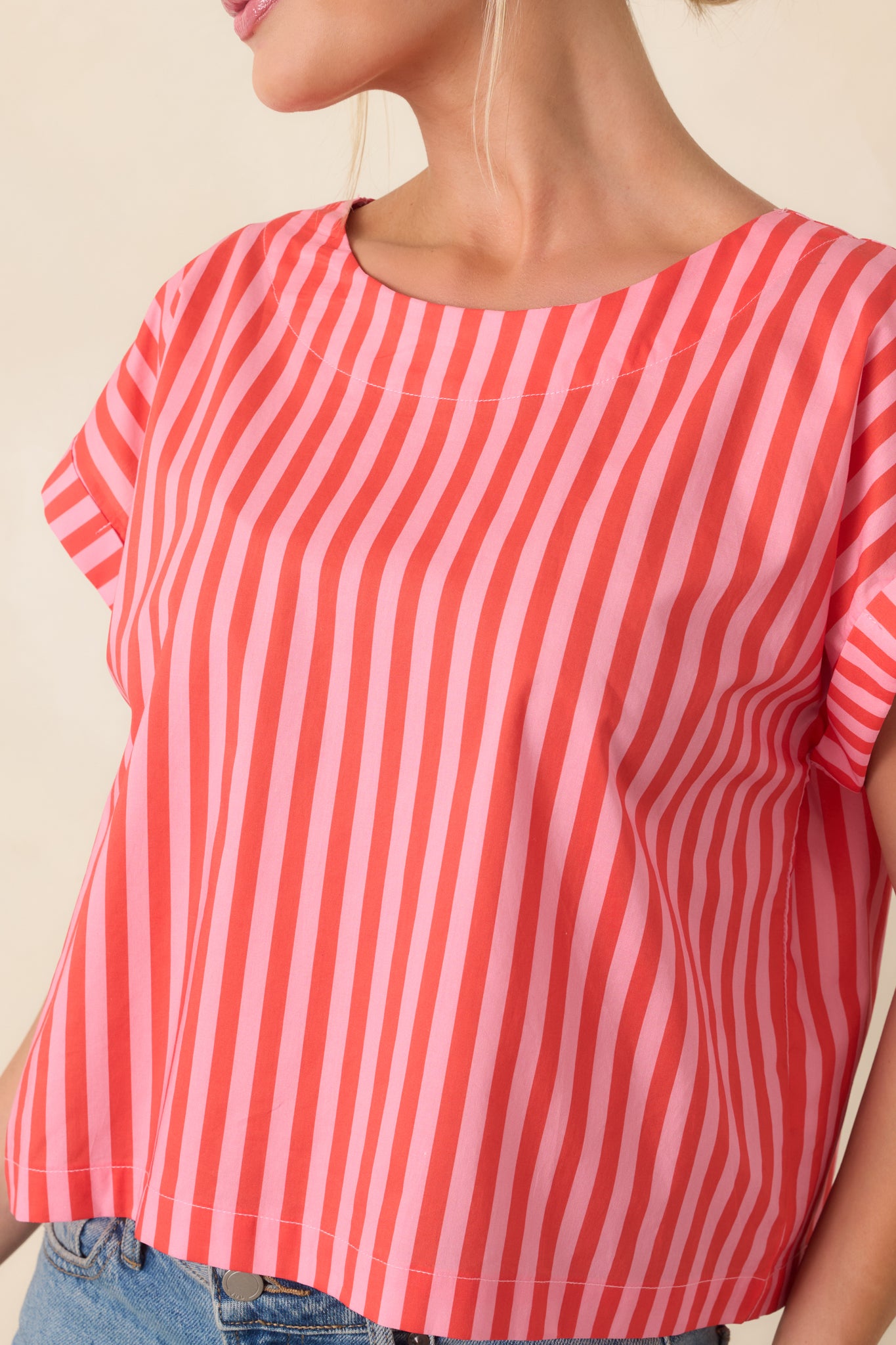 Close view of the striped cotton fabric emphasizing the vertical orange and pink design and relaxed silhouette.