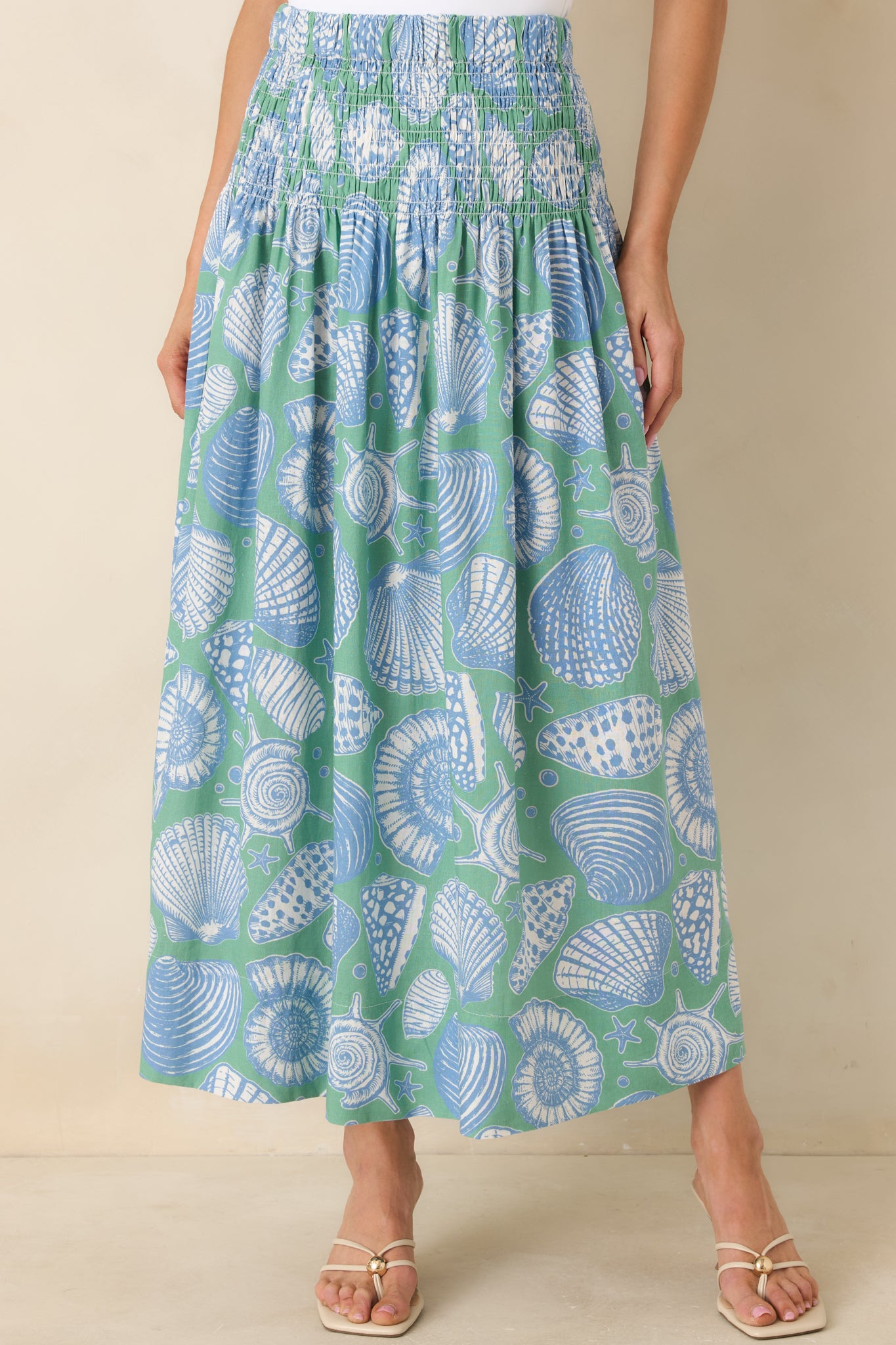 Cropped shot of the piece being styled as a skirt, featuring a maxi length and an oversized shell print.