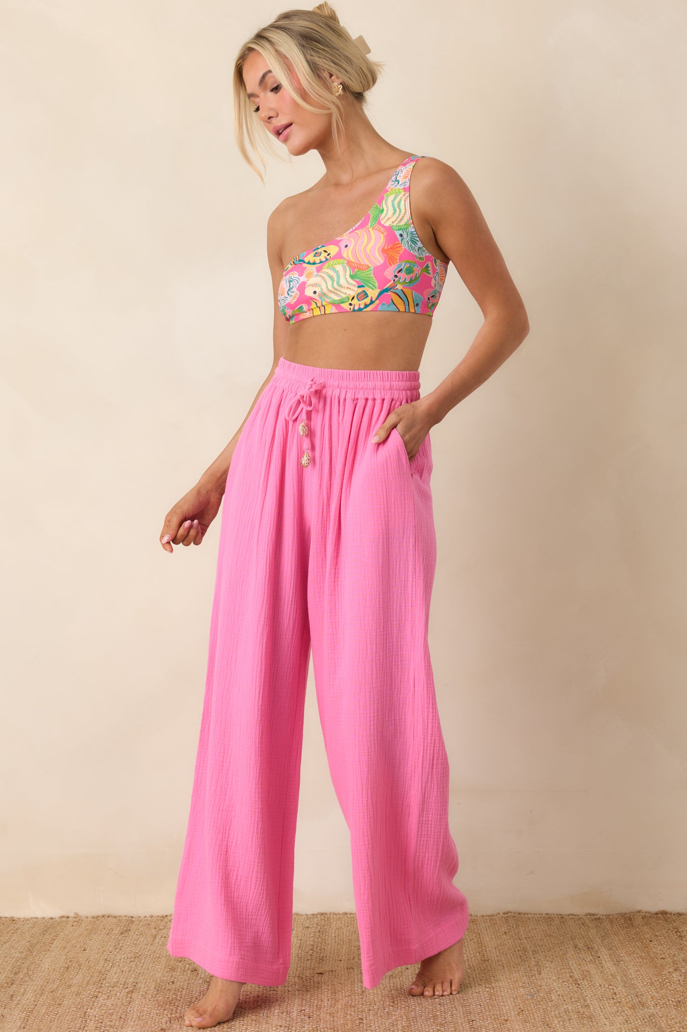 Bright pink textured cotton pants with wide-leg silhouette and adjustable drawstring waistband.
