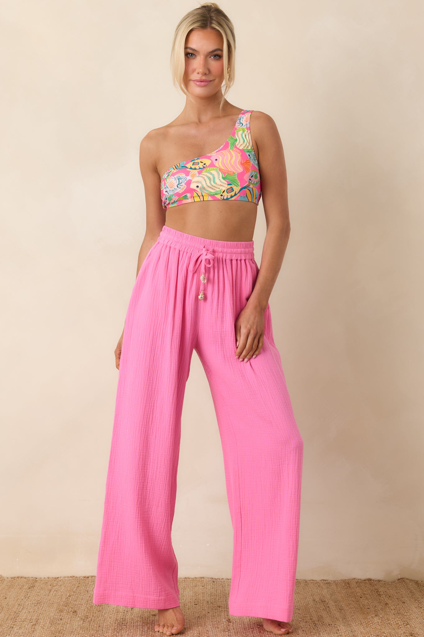Front view of pink one-shoulder bikini top with playful ocean-inspired fish pattern and clean, modern fit.