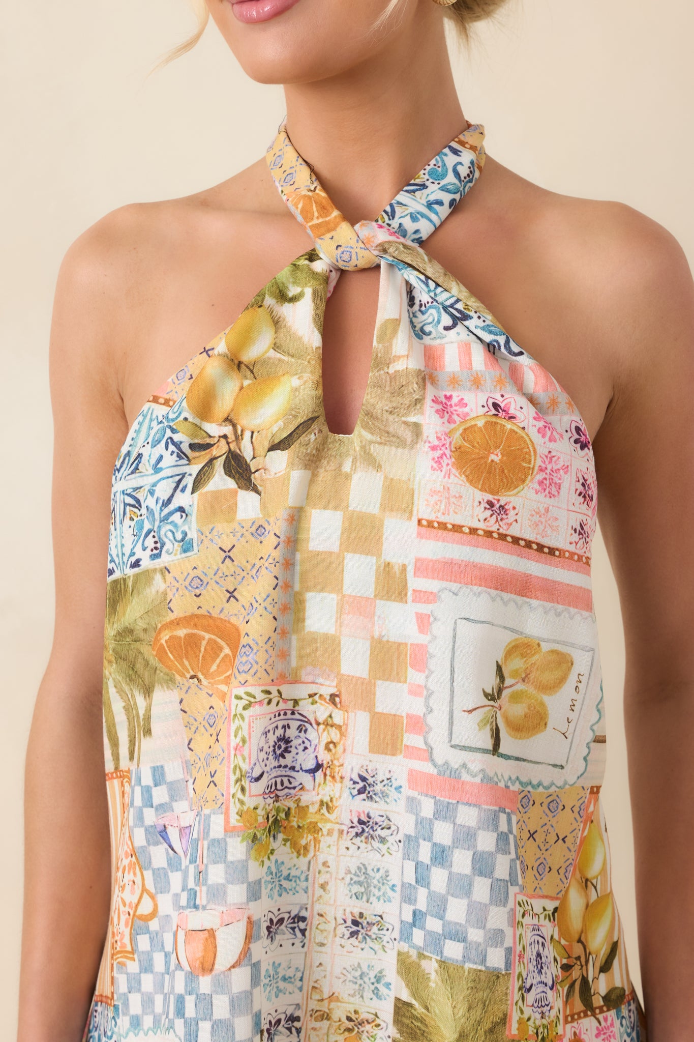 Close-up of the tropical patchwork fabric showcasing citrus, palm, and tiled motifs, with twisted halter and keyhole construction.
