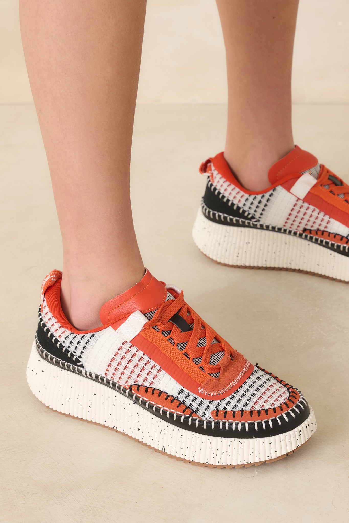 Close view of sneaker upper highlighting contrast stitching and vibrant colors.