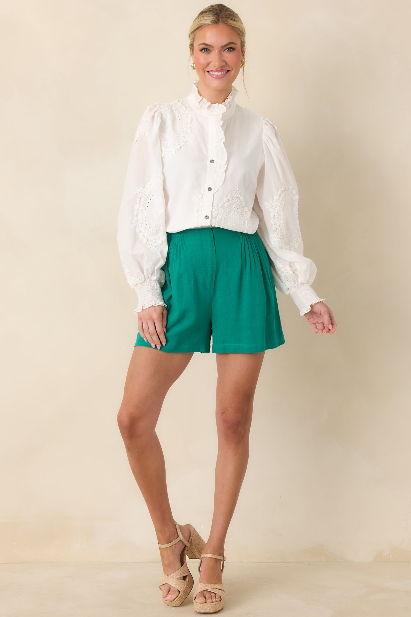 Lightweight woven blouse featuring long sleeves, elasticized cuffs, and delicate eyelet detailing for an airy, elegant drape.