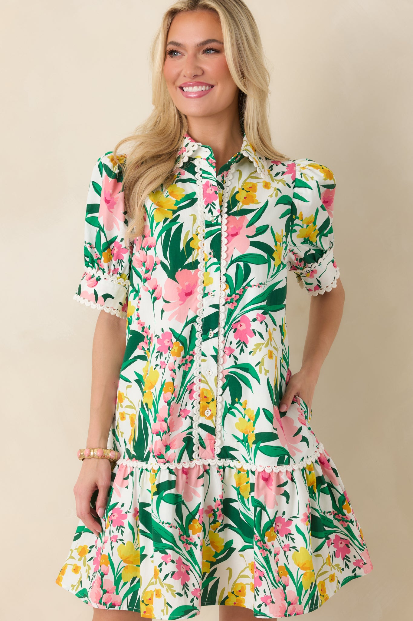 Detail shot of the floral mini dress showing puff sleeves, scalloped trim on sleeve cuffs, and the lightweight cotton fabric.