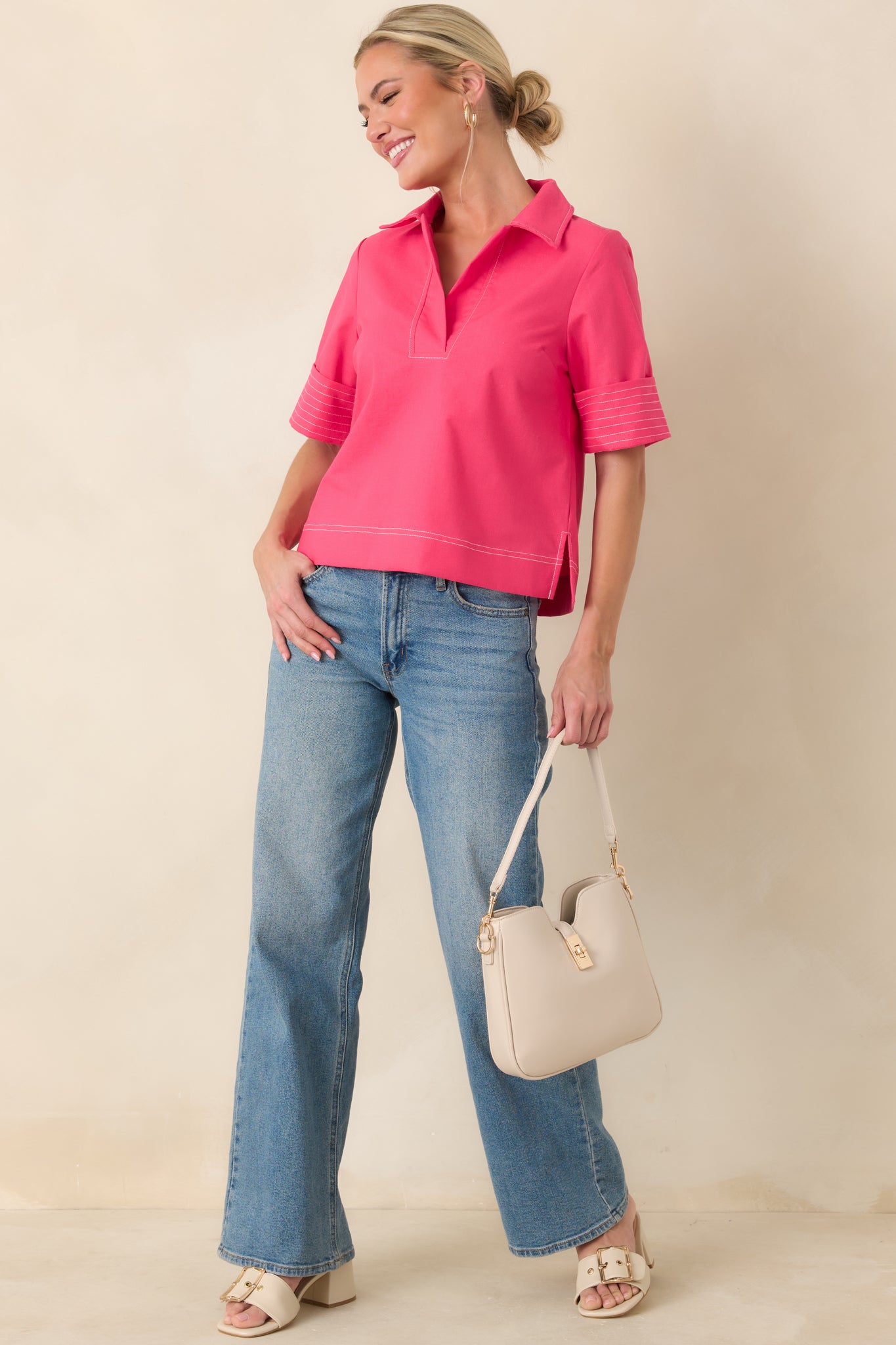 Hot pink short sleeve top with open neckline, contrast seam detailing, and subtle side slits for ease.