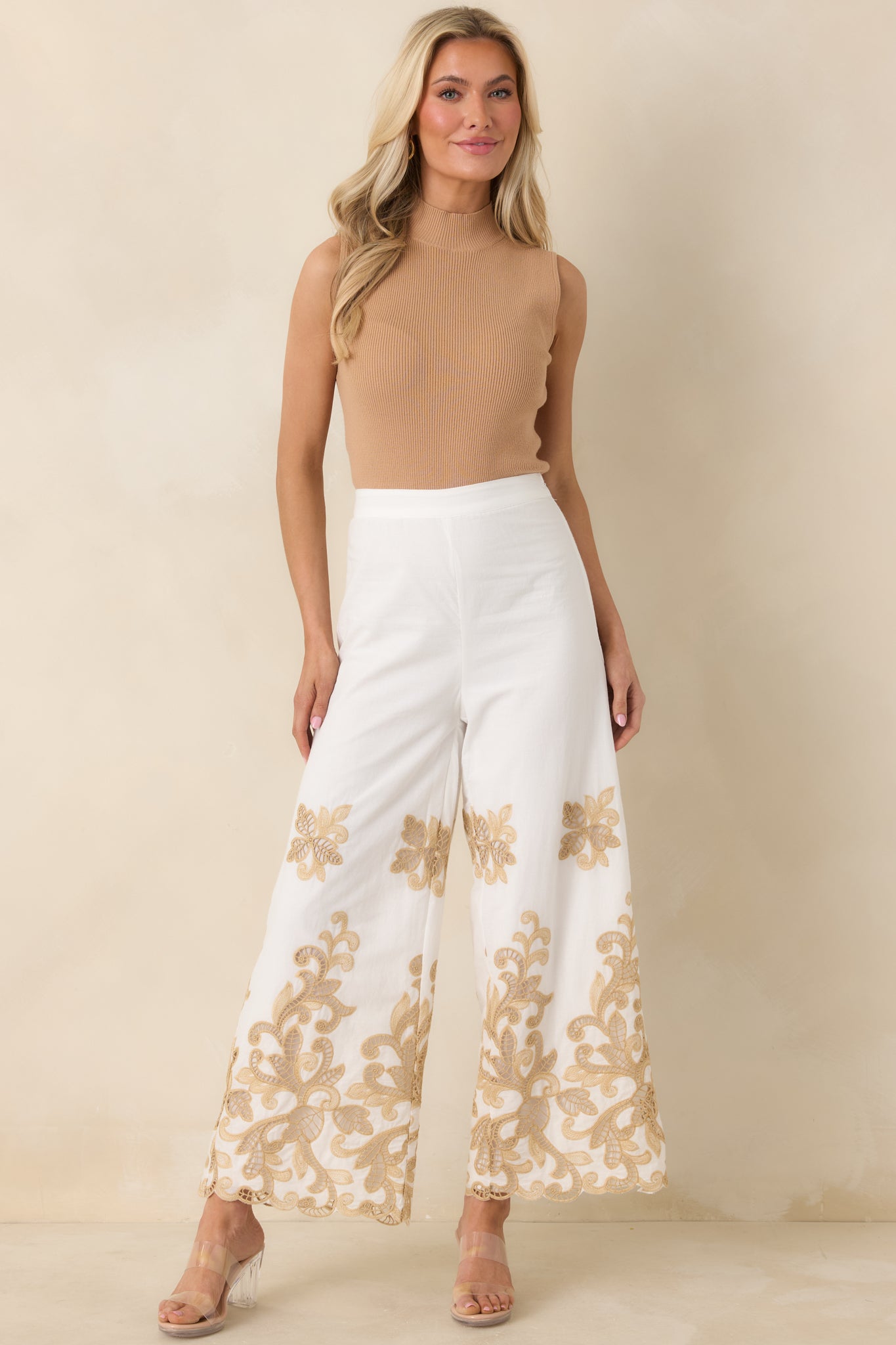 Mock-neck camel top with soft ribbed material and streamlined sleeveless cut.