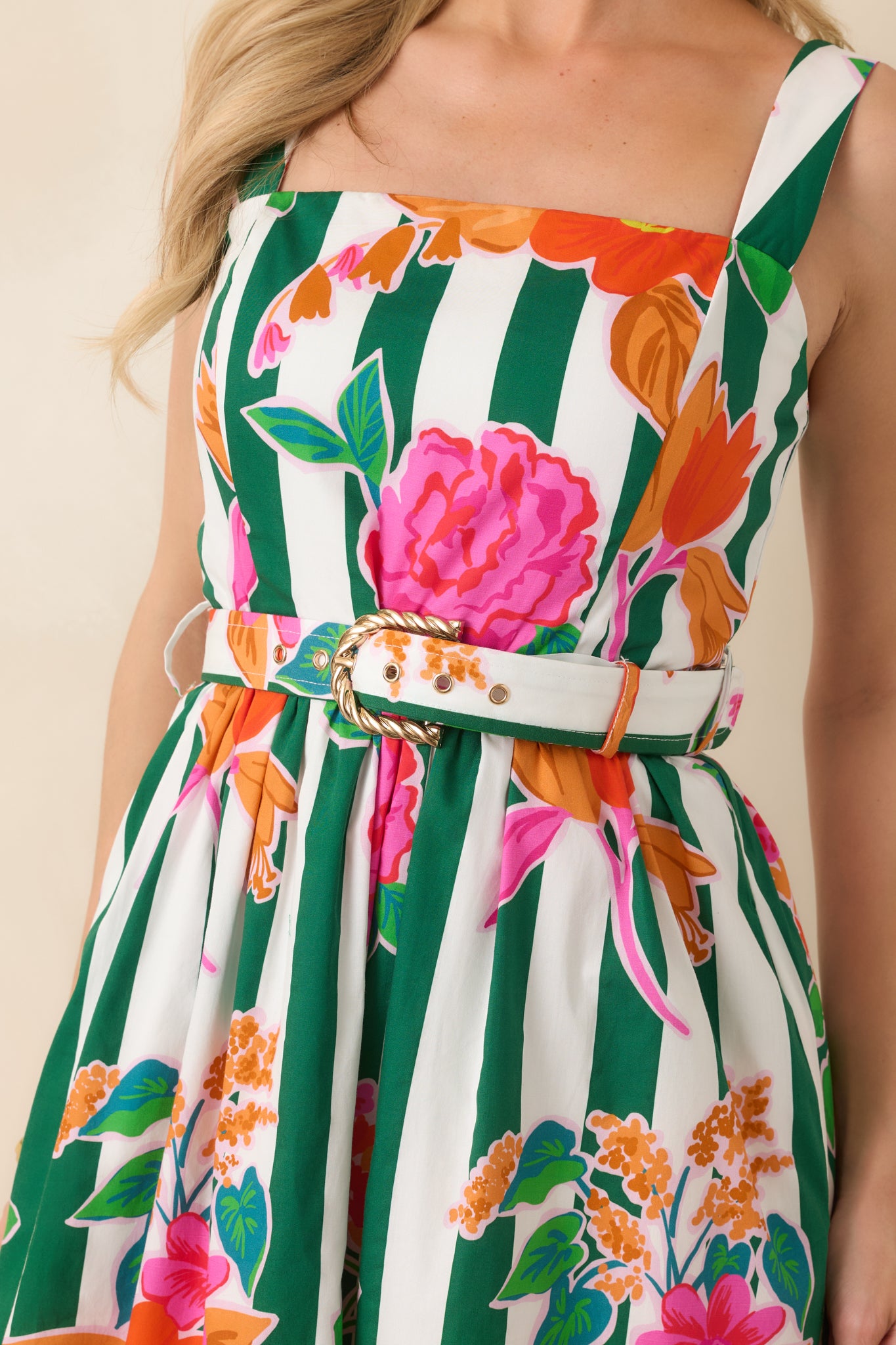 Detailed view of vibrant blooms layered across crisp green vertical stripes with the coordinating belt and gold buckle accenting the waist.