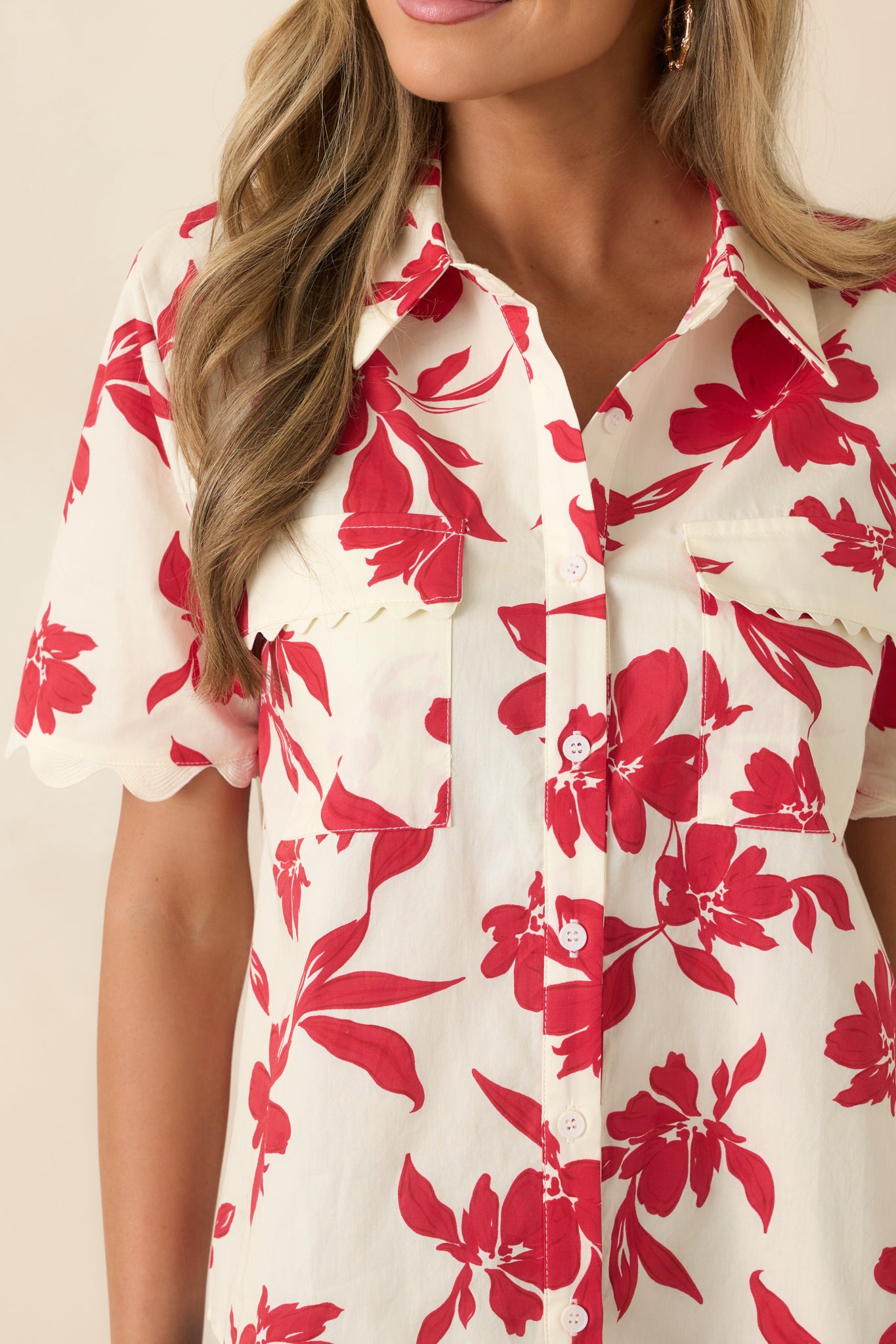 Scalloped pocket detailing on ivory cotton fabric with bold red floral print.